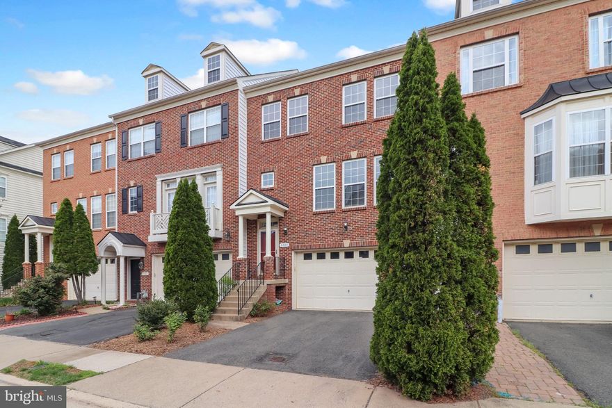 This expansive three-level townhome offers over 2,900 square feet of beautifully finished living space, enhanced by 10-foot bump-outs on every level. Enjoy peaceful wooded views backing to Blooms Park, where you can relax from your bedroom, home office, or private patio while surrounded by nature.

The main level is designed for both everyday living and effortless entertaining, featuring an open-concept layout that seamlessly connects the kitchen, dining, and living areas, along with a versatile sitting space and convenient half bath. The kitchen is a standout with granite countertops, a 6-burner gas stove, stainless steel appliances, and a pantry. Hardwood floors, crown molding, and recessed lighting add warmth and sophistication throughout.

Upstairs, brand new luxury vinyl plank flooring leads to a spacious primary suite complete with two walk-in closets and a spa-like bath featuring a dual vanity, soaking tub, a separate shower and a water closet. Two additional bedrooms share a well-appointed hall bath, and the upper-level laundry includes a newer washer and dryer for added convenience.

The fully finished lower level impresses with high ceilings, a cozy gas fireplace, a full bathroom, and sliding glass doors that open to the backyard, along with direct access to the garage.

The two-car garage includes two separate storage rooms, plus an extended driveway that accommodates two additional vehicles.

Major updates include freshly painted (all three levels since 2024), new roof (June 2024) and hot water heater (Oct 2025).

Enjoy summer days at the community pool and take advantage of the home’s prime location—just a short walk to the Virginia Railway Express for an easy commute to Washington, D.C. You’ll love being close to local favorites including Harris Pavilion, Old Town Manassas, Jiffy Lube Live, and 2 Silos Brewing Co.—with shopping, dining, farmers markets, trails, parks, and year-round entertainment just minutes away.