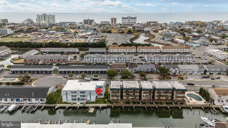 This charming first-floor, canal-front condo offers 2 spacious bedrooms and 2 full bathrooms, ideal for a beach getaway or year-round living. Step inside to find beautiful hand-painted coastal murals, a cozy kitchen with a bright white tile backsplash, and an open-concept layout that flows effortlessly from dining to living space. Natural light floods the unit, highlighting features like a pellet stove that keeps the entire home warm during cooler months. Enjoy outdoor living on the large private deck, complete with a storage closet for all your beach gear. A gate from the deck leads directly to a lush green space and a community BBQ area—perfect for entertaining. Boaters will love the available boat slip  #1, just steps from the unit. Additional perks include a stackable washer and dryer, one assigned parking spot, and plenty of street parking for guests. Located in the heart of Ocean City, you’re just minutes from top attractions, the boardwalk, shopping, and dining. Don’t miss this incredible opportunity to own a slice of the beach life!