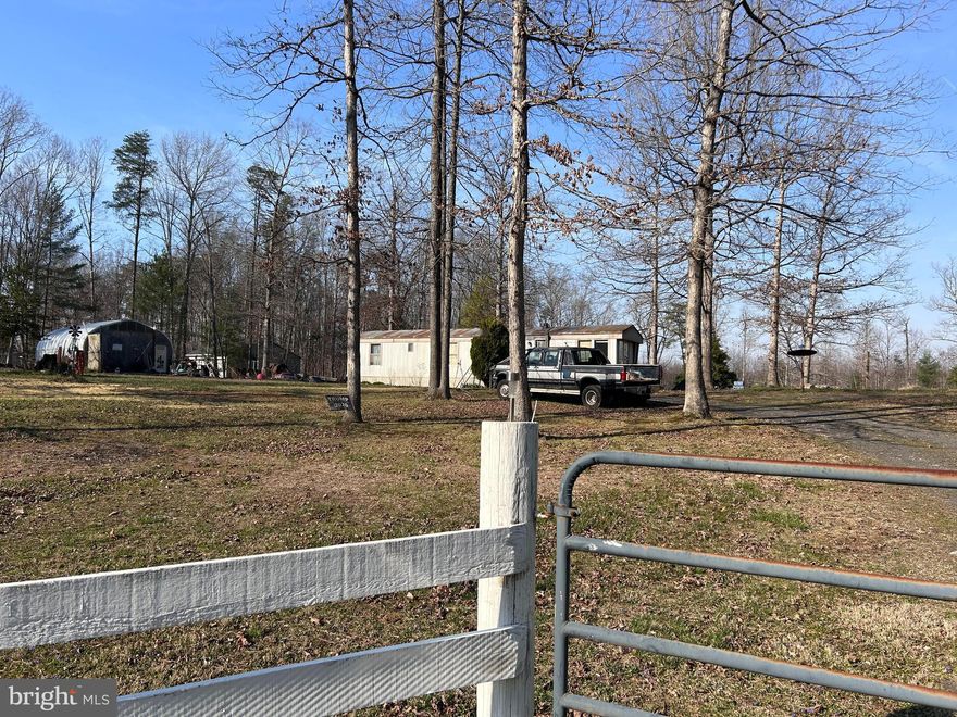 Lovely 3 Acre fenced lot with detached garage, Mobile Home which needs some work but is livable.  Appliances convey, Garage has concrete floor and woodstove, electric as well. Run in Shed, The lot will be cleaned up before closing.