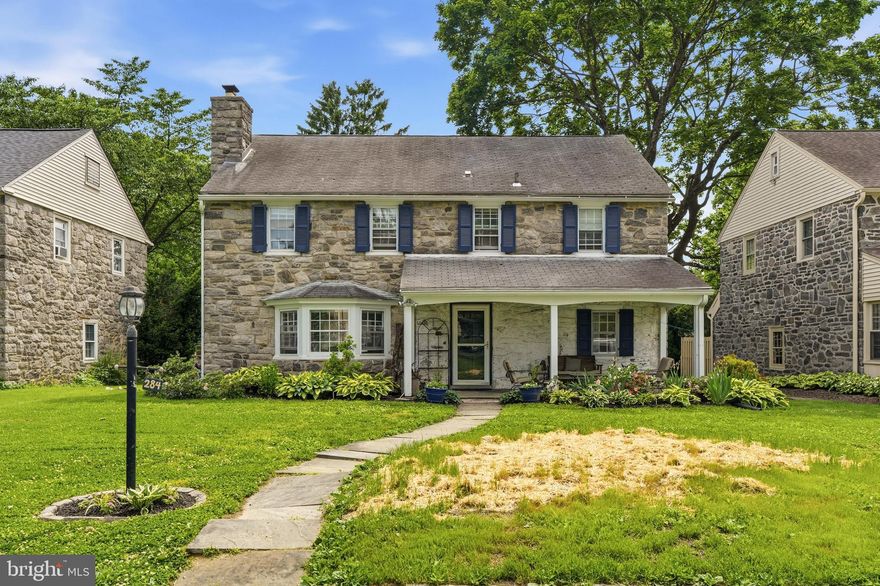 Welcome to 284 Trent Road, a classic stone Colonial in Wynnewood’s sought-after Penn Wynne neighborhood, offering timeless curb appeal, generous living space, and outstanding value in the Lower Merion School District. Set just across from the Penn Wynne Elementary fields and neighborhood green space, this 4-bedroom, 3-full-bath home features a covered front porch, traditional center-hall layout, hardwood floors, a spacious living room with fireplace and built-ins, and a bright formal dining room with a beautiful bay window. The eat-in kitchen offers abundant cabinetry, an island, gas cooking, wall oven, and sliding doors to the rear deck, while a full bathroom on the first floor adds flexibility rarely found in homes of this style. Upstairs are four bedrooms and two full baths, including a generous primary suite with its own full bath and expanded shower. The finished lower level provides valuable bonus space for a media area, playroom, office, gym, or casual hangout, while a full attic offers extensive storage. Outside, enjoy a rear deck, patio, mature trees, and usable yard area. With central air and room to personalize over time, the fundamentals are hard to ignore: a handsome stone Colonial with finished basement space, outdoor living areas, practical storage, and a premier Penn Wynne setting close to schools, parks, shopping, dining, transportation, Center City, and the best of the Main Line.