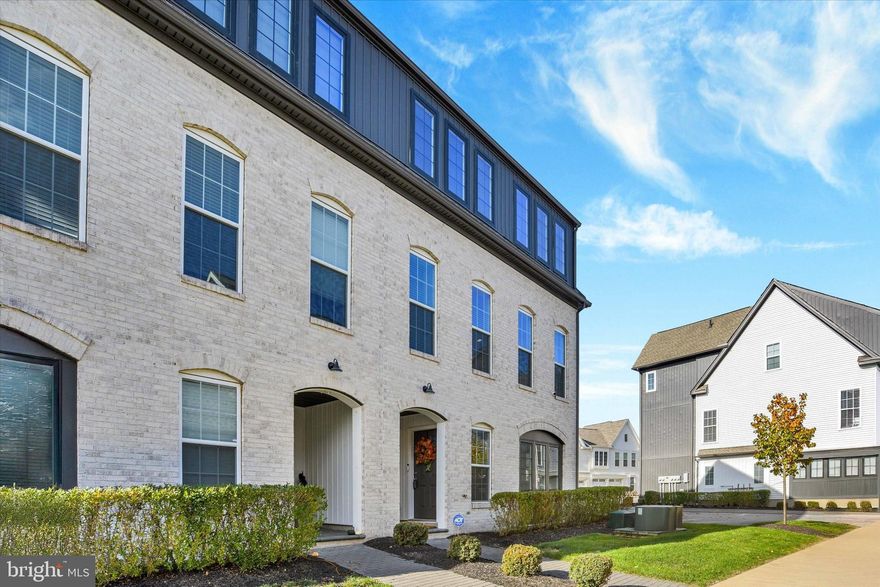 NEW PRICE!!!  Seller willing to give a $2500 allowance toward buying down interest rate.  
Practically Brand New End Townhome in Arcona West!    Move-in ready with 2,336 sq. ft. of low-maintenance living featuring 3 bedrooms (optional 4th), 2.5 baths, and an oversized 2-car garage. Steps from the Arcona Swim Club and Cedar Run Trail, and walkable to Crossroads with IDEA Coffee, THEA, and more.   Entry-level includes a spacious foyer, private office/bedroom, and direct garage access with a Tesla charger. Main level offers an open-concept layout with 9 ft. ceilings, LVP flooring, recessed lighting, a great room with balcony, dedicated dining, and a gourmet kitchen with painted maple cabinetry, navy dine-in island, quartz countertops, stainless steel gas appliances, and tile backsplash. Laundry room conveniently located off the kitchen.  Upper level features 3 bedrooms and 2 full baths, including an owner’s retreat with a large walk-in closet, and en-suite bath with double vanity. ADT security system, ceiling fans in bedrooms, window treatments throughout, neutral paint, plus refrigerator, washer & dryer included. Don’t miss this upgraded, move-in ready home with end-unit privacy in a vibrant, walkable community!