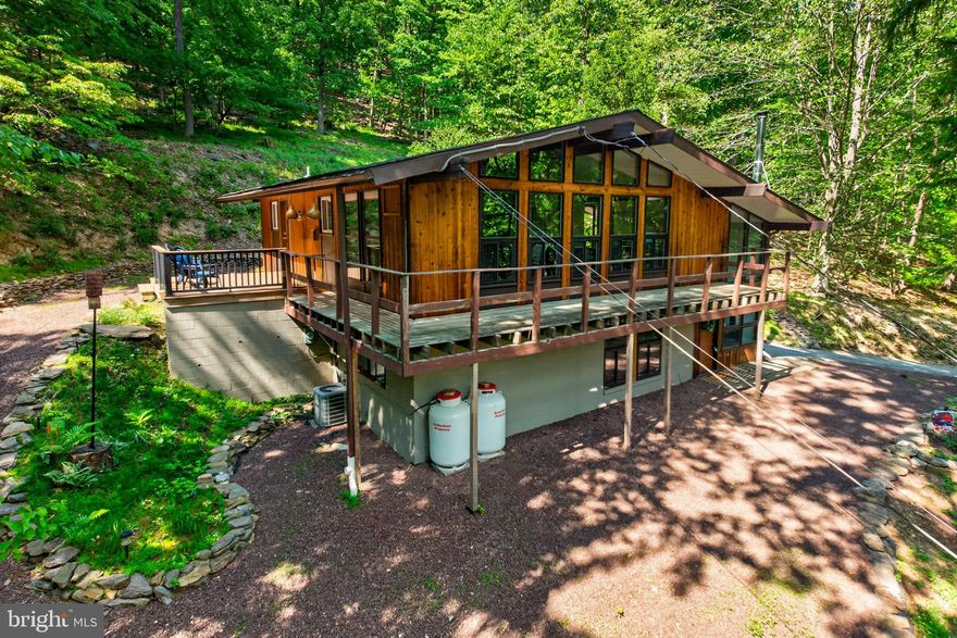 Perched gracefully into the hillside and designed to grow organically from the surrounding landscape, “The Hill House” is a rare Mid-Century Modern retreat designed by renowned architect Art Hannafin, inspired by the artistic vision of Fritz Janschka. Set on nearly 4 acres of tranquil wooded grounds in sought-after Gulph Mills Village and located within the award-winning Upper Merion School District, this architectural gem blends timeless design with nature at every turn.  Clean lines, broad walls of windows, and sweeping views toward Gulph Mills create a seamless connection between indoor and outdoor living. A dramatic two-story entry welcomes you with a wood-burning stove, offering warmth and character on chilly days. On the main living level, the primary suite features a private en suite bath, while a fourth bedroom has been thoughtfully converted into a home office with direct access to the wraparound deck—perfect for working remotely while surrounded by treetop views and the peaceful sounds of nature. The space can easily be converted back into a bedroom if desired.  The open floor plan on the main living level is ideal for entertaining, offering effortless flow between the living, dining, and outdoor spaces. The lower level includes two additional bedrooms, a full bathroom, and laundry area, providing flexible living arrangements for guests, family, or extended stays. Outdoor living is truly exceptional, with multiple spaces designed to relax and unwind. Enjoy morning coffee or evening sunsets from the expansive wraparound deck, retreat to the private sitting area off the rear sliders—ideal for a future hot tub—or gather around the fire pit on the slate patio perched along the hillside while listening to the gentle sounds of the stream below.  Additional features include abundant storage with an oversized shed, utility room, and crawl space. Conveniently located just minutes from the Gulph Mills train station, I-76, King of Prussia Mall, Wegmans, Valley Forge National Historical Park, and Gulph Mills Golf Club, this one-of-a-kind home offers architectural significance, natural beauty, and everyday convenience in an extraordinary setting. Major improvements include a new roof in 2021, main floor windows replaced in 2021, and HVAC heating and central air system replaced in 2019.
Don't miss the video tour!  Showings begin Wednesday May 20th.