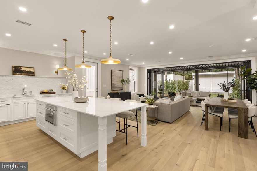 Welcome to 3277 Prospect St NW, a masterfully designed and revitalized home with 4 bedrooms, 3.5 baths, and private parking in the heart of Georgetown. Originally built in 1880, the builder meticulously renovated the home from 2024-2025 with an eye for historic preservation and elevated design finishes that make this home one of a kind, particularly for those who delight in hospitality and bringing people together. Upon entering, the home graciously welcomes you with its hardwood floors throughout, high ceilings, arches, and a light-filled living room with a marble surrounds gas fireplace. The wainscoting and crown moulding pay homage to the home’s history, along with pocket doors that connect to the dining room. The French doors in the dining room also offer versatile options for the space, as it leads to the wine cellar underneath the staircase and the remarkable and breathtakingly beautiful addition to the home. The stunning kitchen boasts a large island that will surely be the heart of the home, custom cabinetry, Carrara marble, Liebherr and Miele appliances, and polished nickel Perrin & Rowe finishes. The wet bar with copper sink and a wine cooler is the perfect space for hosting guests, and it may also become a butler’s pantry for everyday use. Most notably, the additional living room and dining area are enclosed by rare to find folding doors that usher you to the sunroom with heated floor tiles and sliding glass doors. There is a side door that leads to a wrought iron gate and the brick paved driveway as well as to the backyard, which is a peaceful oasis with mature landscaping and floor lighting throughout the brick pathway. The sunroom may also be turned to an open pergola, and the exterior addition’s siding is made of Hardiplank. With the exception of the front exterior, this beautiful home has brand new windows throughout. The upper level has 4 very generously sized bedrooms and large closet spaces. Two of the four bedrooms have their own en-suite baths with heated marble floors and marble walls as well. 3277 Prospect St NW is conveniently close to the exciting shops and restaurants of M St NW and Wisconsin Ave NW and is also located mere steps from locally owned and beloved favorites such as Cafe Milano, Peacock Cafe, and La Bonne Vache along Prospect St NW. The perfect marriage of historic charm and modern and elevated bespoke touches, 3277 Prospect St NW is the place to call home. NOTE: Square footage is estimated by third party.