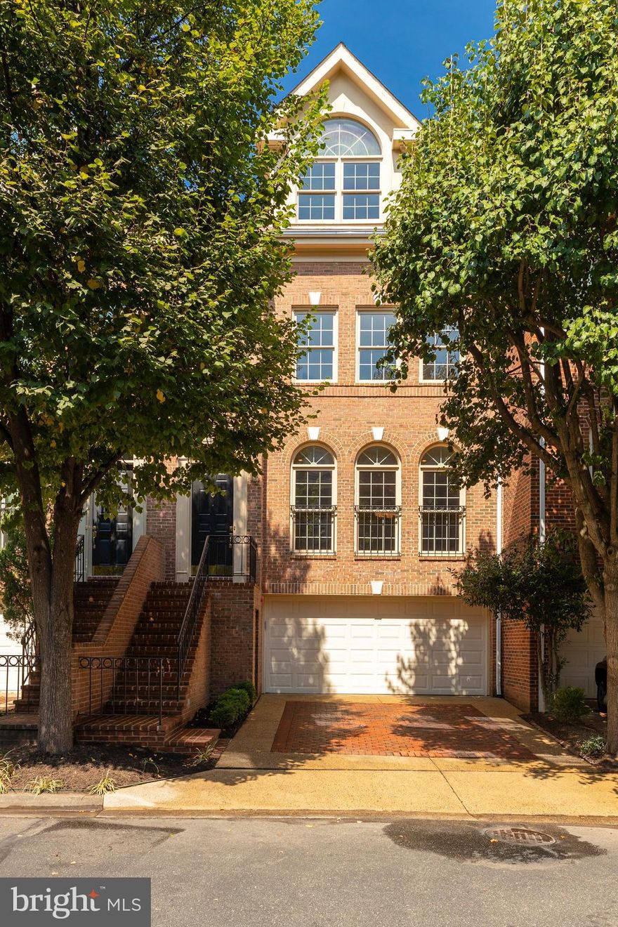 Walk to the Rosslyn Metro, plus the shops and restaurants in Georgetown, from this fabulous townhome in sought after Highgate. Light-filled and spacious, with four bedrooms, this home has one of the largest floor plans in the community. High ceilings, crown molding, beautiful hardwood floors and classic paned palladium windows in the living room are just some of its elegant features. The library has oversized windows, a fireplace and bookshelves. The stunning white kitchen has granite countertops, stainless steel appliances and plenty of counter space plus a separate sunny breakfast room. The huge master suite enjoys lots of windows, views of tree tops, new carpet and a sizable walk-in closet plus an additional closet. The master bathroom features a soaking tub, dual vanities, separate shower, enclosed water closet, linen closet and generous storage. Another large bedroom, full bath and laundry room complete this level. The next level has the third and fourth bedrooms with a full bath and large closets. The enormous lower level has large glass doors leading to the lushly landscaped brick patio. This level offers a half bath plus access to the two-car garage.
