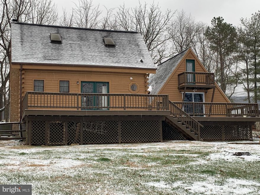 RARE OPPORTUNITY to live in your own cozy cabin in the hills of West Virginia overlooking the Potomac River Valley with the twinkle of beloved Charles Town beyond.   As a primary home or an escape to WV, this log home is as fun as it gets to live on over 1 fenced acre in an all log and wood!  Nestle by the wood stove in the living room or capture storytime while cooking warmed by the pellet stove in the wood floored entry.   Incredibly charming with the warmth living on the land brings.  Modern amenities like a full kitchen, washer, dryer all convey.   The two spiral staircases are efficient use of space and a unique feature leading to two amazing loft bedrooms.  The smaller loft bedroom features wood floors and a balcony.  The primary loft is a beautiful exposed log and beam bedroom with raised wooden floor.   A passage to bring furniture to the loft is conveniently  available.  You will love the expansive ceiling, raised floors and natural light in this private loft. 
Situated on over an acre with no restrictions, you may bring your chickens or other furry or feathered friends and channel your inner pioneer with your own garden and trees. Interior photos coming soo, don't wait to book your tour.