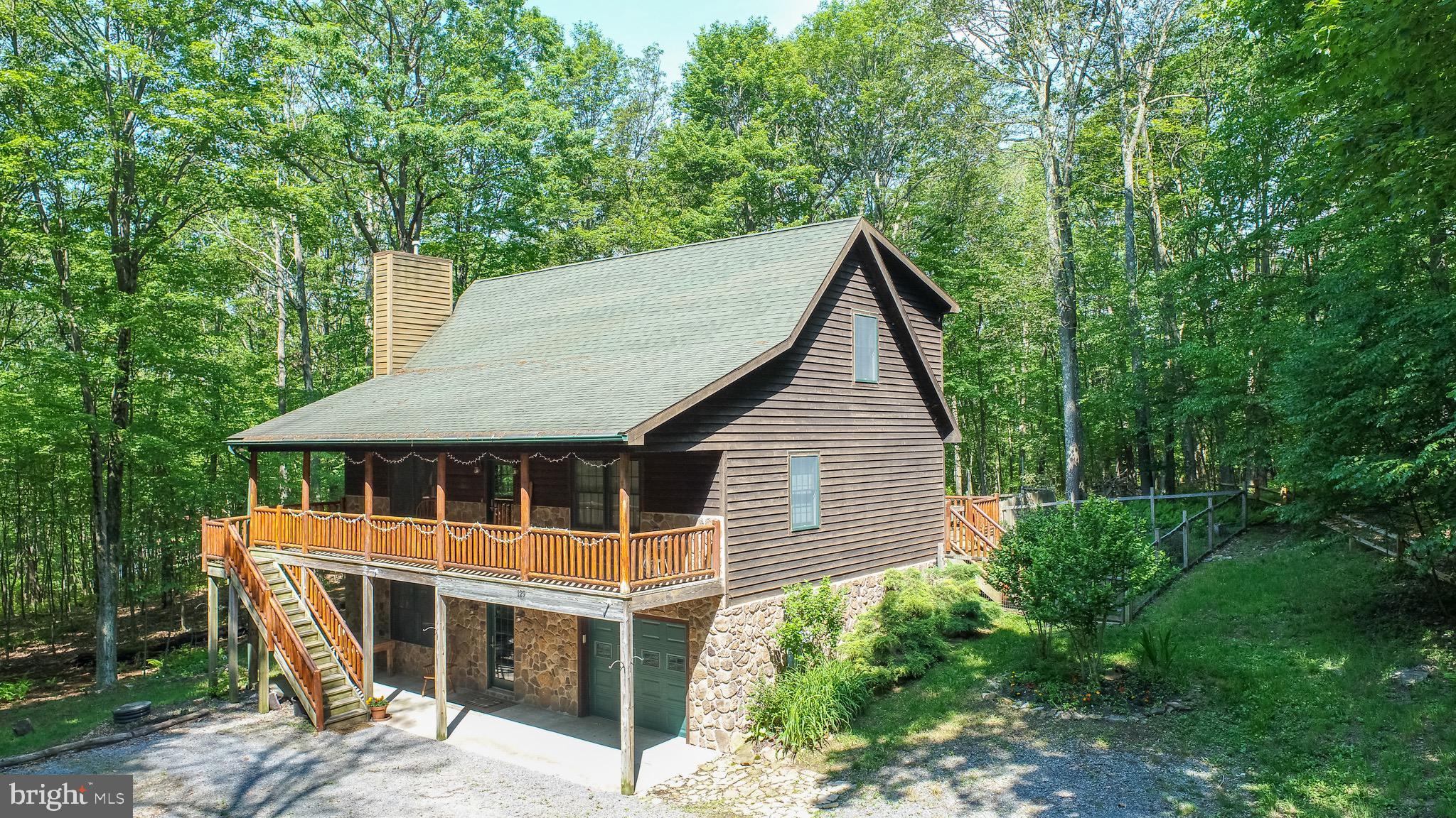 Charming Chalet – Minutes to Deep Creek Lake & Wisp!
Tucked away in a peaceful wooded setting located on a no-thru drive, this 4-bedroom, 3.5-bath chalet-style home offers rustic elegance, modern comfort, and unmatched privacy. Set on 1.12 acres, the property is also being sold with an adjoining separate 1.71-acre perk-approved building lot—giving you nearly 3 acres of serene mountain living and future potential.
Inside, the home showcases three fully finished levels, featuring warm wood ceilings, rustic accents, and a stunning floor-to-ceiling stone gas fireplace in the main living area. The open-concept floor plan seamlessly connects the kitchen, dining, and family room—ideal for both entertaining and everyday living. The main level also boasts a spacious primary suite with a private bath, a dedicated laundry room, and access to a large covered front porch perfect for morning coffee or evening relaxation and rear deck both with hand-painted pine railings.
Upstairs, you’ll find a charming loft overlooking the great room, two more bedrooms, and a full bath. The walk-out lower level offers a cozy second living area with a second gas fireplace, an additional bedroom and full bathroom, and interior access to the attached 1-car garage.
Modern updates include a Kinetico water conditioning system, Noritz tankless hot water system, a Payne furnace for heating with central air, and stainless steel appliances (Frigidaire oven/stove and LG microwave).
Outdoor features are abundant: a fenced backyard, a separate fenced garden area, beautiful landscaping and garden beds, a fire pit, and a large garage shed—all surrounded by nature and mature trees.
Located just 15 minutes from Deep Creek Lake, Wisp Resort, and I-68 - and only 20 minutes to several state parks, this home combines peaceful mountain living with convenience and opportunity.
Whether you're looking for a full-time residence, mountain getaway, or an investment with expansion potential, this unique property has it all!