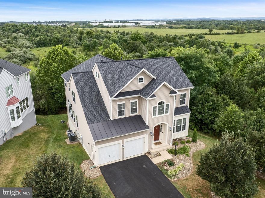 This stunning 6-bedroom, 5.5-bath home offers space, style, and modern updates in a prime location that is convenient to commuter routes. Nestled on a tree-lined lot that backs to the battlefield with a wet-weather creek, creating a setting full of character and privacy. The property is located off of a private drive and has a freshly painted exterior enhanced by beautiful new landscaping. The main level features hardwood floors throughout, a cozy living room with a fireplace, and a gourmet kitchen complete with Silestone countertops, double oven, island, and abundant natural light. Upstairs you’ll find five spacious carpeted bedrooms, including a primary suite with a sitting area and luxurious en-suite bath with a soaking tub and dual vanities, plus the convenience of a second-floor laundry. The fully finished basement expands your living space with a bedroom, full bath, large living area, charming fireplace, and a bright and airy three-season room, all prewired for speakers and a projector—perfect for entertaining. With a newer roof, newer HVAC units, and water heater replaced in 2023, plus a two-car garage and easy access to neighborhood amenities across the street, this home combines comfort, elegance, and convenience.