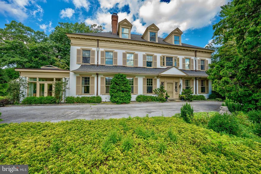 Nestled at 142 Grays Lane, this elegant 1900 manor home exudes timeless charm in the prestigious Main Line neighborhood of northside Haverford.  Historic Atlas map of 1908 shows this home, named "Wayside". 
Situated on a picturesque 1+ acre property, the residence boasts natural landscaping, mature plantings, shaded paths, and quiet corners. The separate carriage house accommodates 3 cars and features a small apartment above, while an additional detached garage closer to the main house offers space for 2 cars. A flagstone terrace, stone walls, and walkways surround the central heated pool, creating a serene outdoor oasis. The 3-story manor home, spanning 7500 sq. ft., showcases stunning architectural details and hand-carved moldings. Secluded behind a high wall, the circular driveway ensures privacy and tranquility, making this residence a luxurious and captivating retreat. The grandeur of this distinguished residence is evident from the moment you step into the foyer adorned with Mercer tile flooring, wainscoting, and massive doors. The main floor boasts a grand Center Hall with wainscoting, carved archways, pocket doors, and 10' ceilings, and a beautiful curved staircase with palladium windows. This central room also leads to the Powder Room, under stairs coat closet, and glass door to a flagstone walkway and terrace. The elegant living room offers stunning millwork, a fireplace, and French doors to the covered porch. A wide hallway leads to the library with  marble fireplace, built-ins, and pocket doors, culminating in the dining room adorned with a marble fireplace, Mercer tile hearth, and crystal chandelier and sconces. Two sets of French doors open from the Dining Room into the stunning family room.  This room also known as the Sunroom, is illuminated by three walls of glass,  a vaulted glass ceiling  with open beams, and an amazing design that blends exterior light and views of landscaping with interior spaces.  This brilliant living area  seamlessly connects to the spacious kitchen with light wood cabinetry, granite counters, stainless steel appliances , and a walk-in pantry closet. The kitchen adjoins a separate Butlers Pantry, Laundry Room and outside entrance.  The second floor reveals a central open space with three bedrooms, each connected by Jack and Jill bathrooms, a 4th Bedroom with hall bath, and the primary bedroom suite offering a fireplace, soaking tub, large stall shower, and two walk-in closets.  Two secondary Bedrooms also boast beautiful fireplaces. The third floor features an artist's studio with an open beam 9' ceiling and recessed lighting, along with 2 additional bedrooms, a hall bath, a cedar closet, a darkroom, and attic storage. The basement is full and unfinished, offering a workshop, half bath, extensive storage, a walk-in safe, and an outside entrance. The entire property is fenced and an electric gate encloses the backyard.  Throughout the years, the original architectural and design features of this extraordinary home have been meticulously preserved while also updating  amenities for today's lifestyle.  Properties of this caliber and quality, in this superb location, are rarely available and this is the first time offered in over 50 years.  Don't miss this opportunity!