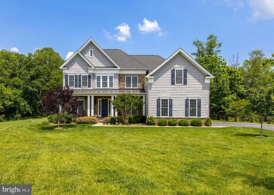 Rarely available in the coveted Weatherstone community! Tucked at the end of a quiet cul-de-sac, this stately 6,400+ sq ft home is privately sited on over 2 acres surrounded by mature woods.. A charming covered front porch welcomes you home, while the lushly landscaped yard provides beauty and privacy in every season.  Inside, the meticulously maintained open floor plan showcases a spectacular gourmet kitchen with an oversized granite island, stainless steel appliances, subway tile backsplash, and custom cabinetry—perfect for everyday living and entertaining. Rich hardwood floors flow throughout the main level, which also features a Great Room with a dramatic two-story stone fireplace and motorized blinds, an elegant wine bar, spacious dining and living rooms and a private home office.  A sweeping curved staircase leads to the luxurious primary suite with a private sitting room, spa-inspired bath with soaking tub, frameless glass shower, and dual walk-in closets. 3 additional bedrooms, 2 full bathrooms and  laundry room complete this level.  The finished lower level offers incredible versatility with a family room with gas fireplace, fitness room, wet bar, and full bath. Step outside to enjoy a private backyard complete with low-maintenance Trex deck, a spacious patio, and a built-in firepit.  Enjoy the serenity of Weatherstone’s natural setting, combined with proximity to top-rated schools, premier hospitals, upscale shopping, and vibrant cultural amenities. Convenient to I-695 and I-83 for an easy commute to Towson, Baltimore and beyond.