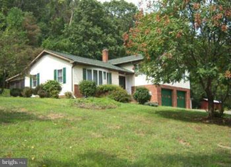 SPLIT LEVEL ON LARGE ACREAGE- You will love the privacy of this three bedroom two bath custom built brick & vinyl home on 11.22 open and wooded acres  located just minutes from historic Berkeley Springs, WV. Features include porch, deck, foyer, large kitchen and dining room, family room,two car attached garage and outbuildings. Updated with new carpet and vinyl. Lots of privacy.