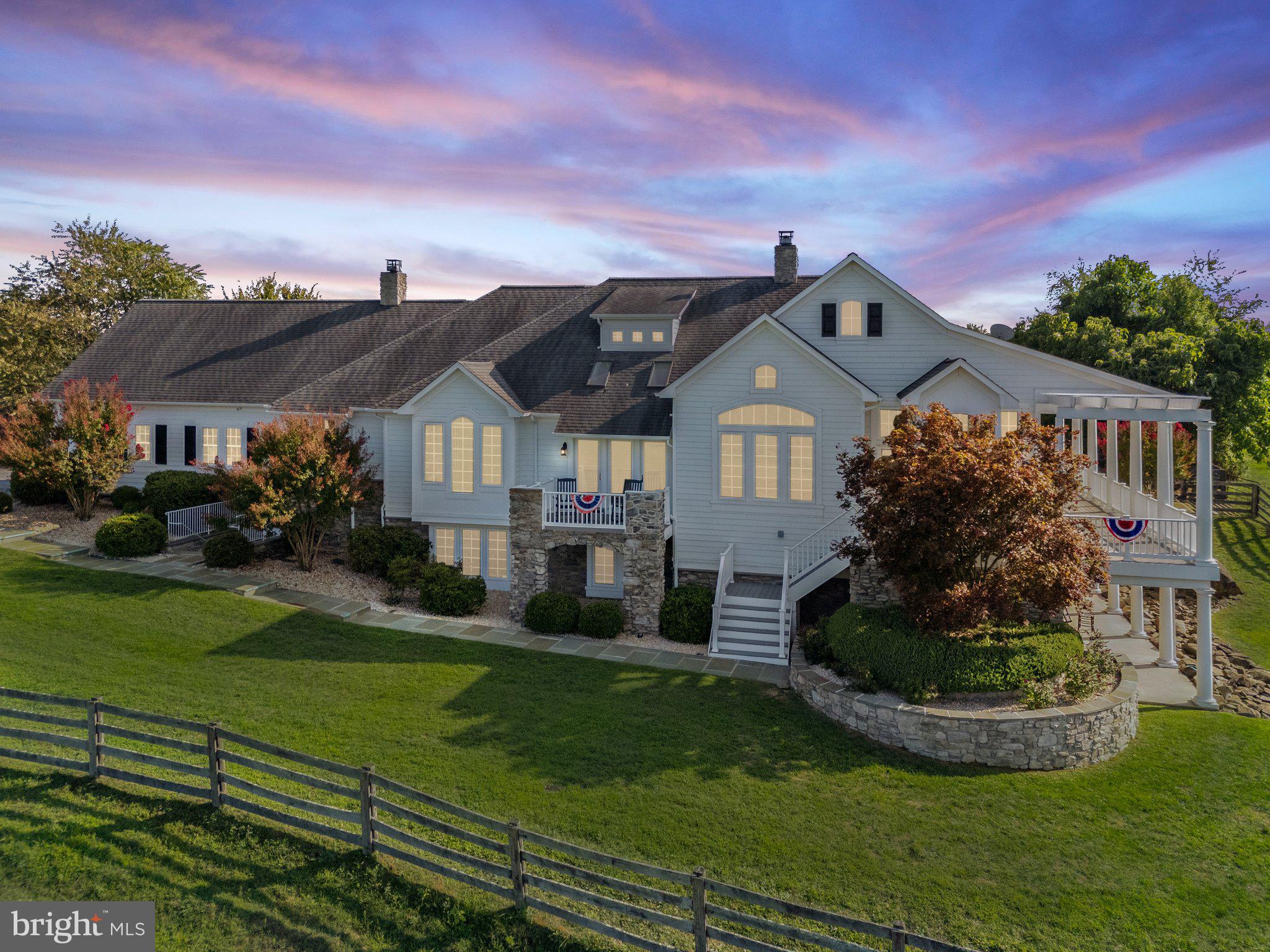Nestled between vineyards, pastures and babbling Beaver Dam Creek, in the quiet community of Round Hill, this serene 4 Bedroom, 4.5 Bath Chadsworth Custom Home stands ready to welcome you home.
The sprawling rambler has a cozy feel and offers 2,992 sq ft of main level living complete with a spacious Country Kitchen, Breakfast Room, Dining Room, Parlor, Primary Suite, 2 Offices, Family Room, Laundry and separate Mudroom. The 2704 sq ft Lower Level features 3 additional Bedrooms, Bonus Room with egress window and Bonus Room without egress window, 3 Bathrooms and Rec Room with exterior entrance from the front of the home and plentiful storage.
The wrap around porch and patio below provides luxurious outdoor living and panoramic views of of the 14.12 acres which include manicured landscaping, rolling pastures, a rambling creek, a neighboring vineyard and sunset views of the Catoctin Mountains.
A separate 1500 sq ft barn is located on the western side of the property. The barn has electricity, an overhead door and a man door for easy access to the interior. The interior has both concrete and dirt floors. The property includes 2 parcels totaling 14.12 acres.
The property is currently in Land Use.
APPOINTMENT ONLY WITH 24 HOURS NOTICE. LISTING AGENT MUST ACCOMPANY