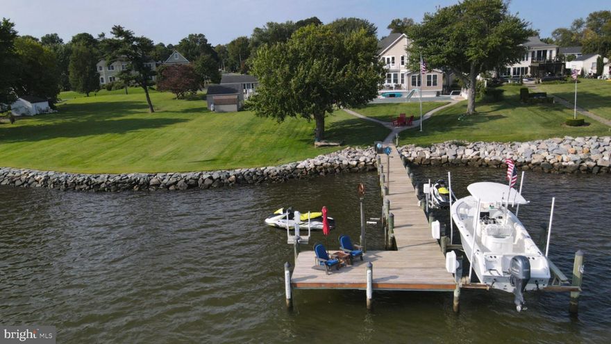 Beautiful contemporary with soaring ceilings, hardwood floors and wall of glass looking out to the waterfront pool and sweeping views of Broad Creek.  Protected water, yet a quick trip to the Bay.  Home includes the open floorplan everyone wants.  New three season sunroom poolside is great for cracking crabs.  First floor office can be used as a bedroom, with a full bath just around the corner.  The main level flows out effortlessly to extensive decking overlooking the large pool and new gazebo.  Pavers take you down to the waterfront firepit and out to a freshly decked dock that includes boat lift, two jet ski lifts and a nice seating area.  Large primary bedroom has great water views and a scrumptious primary bath remodeled just this year.  The Primary isn't just a bedroom; it's a suite of rooms that also includes an office; huge walk-in closet and waterfront balcony.   The laundry is on the second level for convenience, and the other bedrooms are all generous in size.  Bay City Community offers two waterfront parks, one with a boat ramp, picnic area and kayak rack.  The other has a tot lot and open areas with magnificent views of the Bay and Bay Bridge.  It's a great getaway, yet close to everything you need!