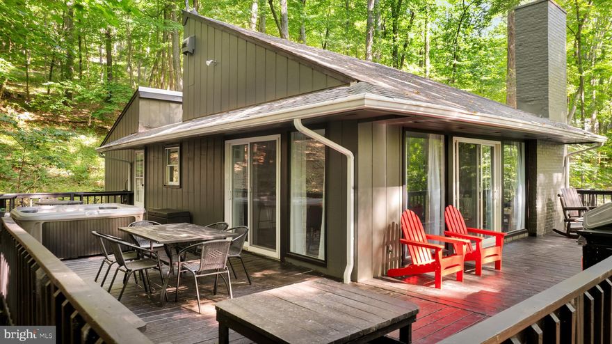 Charming home with a stone fireplace, vaulted ceilings, and a stunning two-story living area filled with natural light from large windows. The spacious kitchen features bar seating and flows into a bright dining area. Enjoy the wraparound deck, upstairs reading nook, and a generous yard perfect for relaxing or entertaining.  Professionally designed with all new furniture, modern decor, and hot tub. As a vacation rental it has generated $88,000 over the past 20 months ($57k in the past year alone!), and can come with an existing property manager and cleaner.   This cabin is located in Coolfont Resort, a private community with an outdoor pool & hot tub, and miles of hiking trails – and just 10 minutes from downtown Berkeley Springs.   Hot tub and furniture optional, available for purchase.  See seller docs for a summary of rental history and financials.  $1,000 buyer credit if you continue using the same property manager.   Perfect primary residence or vacation home!