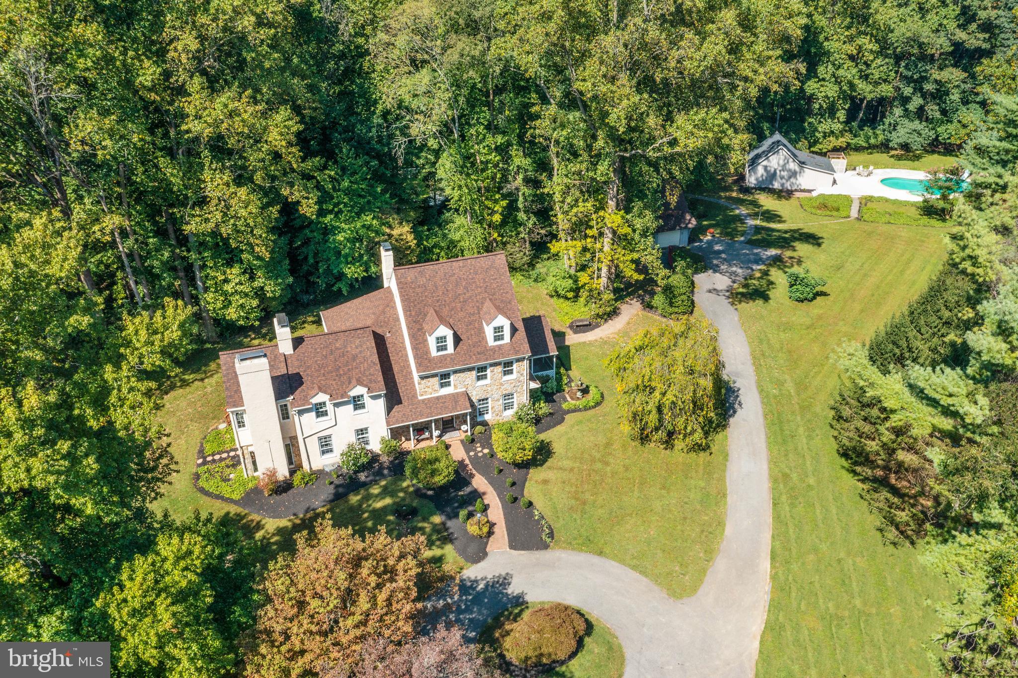 Rarely does a truly unique, estate property like this one become available. Situated on 16.6 acres in Chadds Ford this property includes open fields, woods and a stream. Located in the AWARD WINNING Unionville-Chadds Ford School District, ranked top 2% in the nation by US News & World Report, this property is adjacent to horse farms, convenient to Route 1, and a short drive to Philadelphia, Wilmington and Maryland. The estate consists of the main residence, a detached two car garage, a TENNIS COURT and a beautiful IN-GROUND POOL complete with an adjacent pool house which has a second kitchen, a full bathroom and shed storage for outdoor equipment or a work/hobby space. The long driveway offers pastoral views as you approach the elegant 3 story home complete with a circular driveway entrance, brick paver walkway, manicured landscaping, and a welcoming front porch. This home offers gorgeous hardwood floors throughout, custom moldings, and beautiful built-ins which are just a taste of the quality and attention to detail you will find in this splendid residence. To the right of the main entry is the formal dining room with a breathtaking bay window that frames the nature and water fountain just outside and a large wall of built-ins which make the perfect place to store all the crystal and fine china and entertaining accoutrement. To the left of the main entry is the half bath and office/library. The center hall also opens to a gracious formal sunken living room with a gorgeous fireplace, built-in bookshelves and cabinets, and a corner cabinet wet bar. French doors lead to the sunroom with a brick floor and walls of windows which allow the outdoors in. The back of the house has the cozy family room complete with a large wood burning fireplace, built-ins and an exposed wood beam that adds to the charm and character of the space. The adjacent Chef’s Dream Kitchen is both stylish, spacious, and functional. The countertops are real quartz, the backsplash is a beautiful marble mosaic, the island in the kitchen is almost an entire slab of stone with plenty of space for the cooktop, seating around the island, storage, and meal prep. Within the kitchen, there is a built-in desk, pantry storage, and an area for the kitchen table overlooking the attached, screened in porch. The screened in porch and deck just beyond provide the perfect place for outdoor dining and enjoyment of this magnificent property. The second floor offers generously wide hallways. The spacious master suite includes a huge, walk-in closet, French doors that lead to a large sitting room with fabulous views of the countryside and complete with fireplace and a whole wall of windows and separate outside entrance, plus a lovely master bathroom with a custom marble shower, two vanities, and a separate toilet room. The remainder of the floor consists of a cedar closet, laundry room, full bathroom, and three additional bedrooms (one of which is being used as a workout room). The third floor would be an ideal space for a live-in nanny-suite or separate living quarters; it consists of two bedrooms and a full bathroom. The finished basement provides for a wonderful entertaining and recreation space. From the game room with classic wainscotting and built-in wet bar, to the second office area, to the sunken additional family room space and half bath, this level has it all. Stucco has been inspected and repairs completed. HVAC new in 2022. Estate properties of this caliber in highly sought-after, top-rated school districts rarely become available. This is truly an exceptional property that you and generations of your family would be proud to call home.