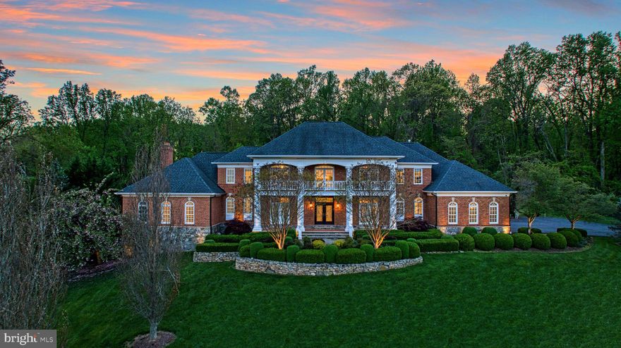 This stately brick-wrapped Beacon Hill treasure boasts just over three lush acres where professionally lit landscapes serve as the backdrop for an entertainer’s paradise. A home of low-country charm with meandering drives, multiple balconies, and sweeping hillside-privacy, the home unfolds to 10,139 square feet showcasing coffered ceilings, sky-high windows, multiple fireplaces, hand-milled trimmings, and picture-perfect Juliet balconies. While meals prepped in the buttercream kitchen are a breeze using professional-grade appliances, custom cabinetry, heated floors, and butler’s pantry, little loved ones will be eager to assist, awaiting from the adjacent cozy gathering space. Here, weeknight games and warmth can be stowed within built-ins, while, in the main living room, a soaring ceiling and leaded-glass windows impress holiday guests. Toast to celebrations in the dining room of timeless checkered tiles, then retreat for a bit of business, play rounds of billiards, or listen to a baby-grand within dedicated vistas for each. While your main level is complete with guest suite and tucked-away bar, your outdoor playground hosts small and large affairs using a stone-lined patio, heated pool, sport court, putting green, and beds ready for flowering or kitchen garden dreams. In the lower level, endless accommodation includes a home theater, catering kitchen, and post-swim changing rooms with steam-shower. Found among six sun-lit bedrooms - five with en suite baths - your primary sanctuary allows for quiet reads, evenings in the soaking tub, privacy on the terrace, and keeps garments within an exceptional place to dress. While on tour, visit the home’s cozier nooks and crannies including mudroom, playroom, storage, and home gym, and ask after the high-end security, sound, and energy efficiency systems. From your three-car garage, unplug from your electric car charging station and drive towards adventure throughout Loudoun, where hunt and wine culture, historic towns, bustling OneLoudoun, IAD, and beyond await.