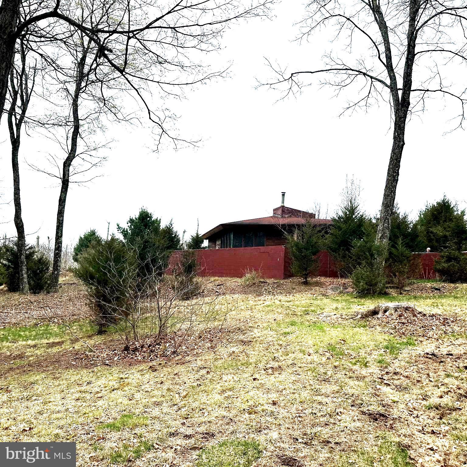 Welcome to your little slice of heaven where you truly can get away from it all in the woods of bucolic Bucks County! This mostly wooded property spanning nearly 12 acres is accessed via a long winding dirt driveway that crosses a small stream so owning an suv or 4 wheel drive vehicle is a must unless improved. Make your way up the hill to the house and you'll be amazed at the serenity and beauty of the location. The current dwelling is a 1 bedroom 1 bathroom home constructed based upon an original Frank Lloyd Wright design. To say the home is unique would be an understatement. Update and make it your new home, rental or weekend get away. Or design and construct an entirely new home and perhaps the current dwelling becomes the pool house? So much potential here...priced to move fast. Estate sale. Do not enter property grounds or driveway without an appointment.