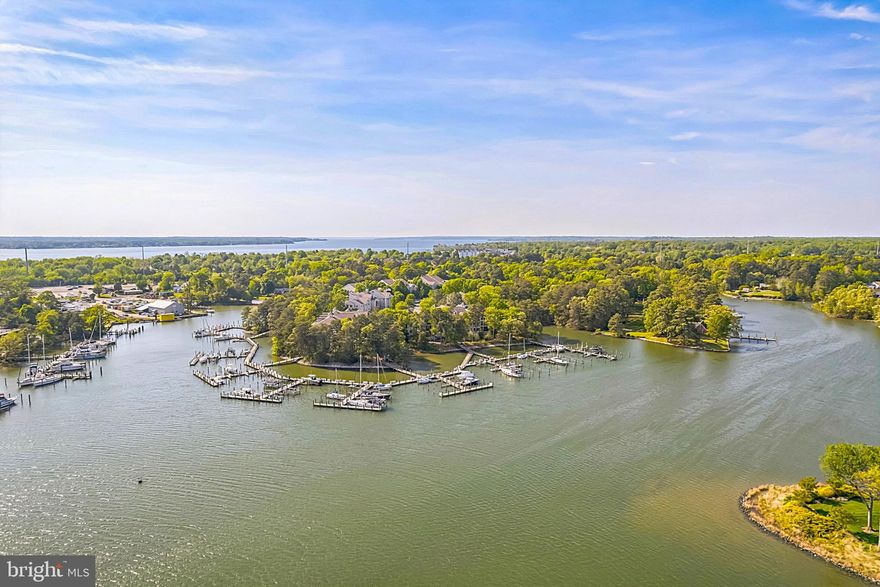 Enjoy great community amenities and the waterfront lifestyle in this attractive Solomons Landing condo. The unit offers an open floor plan, one of the larger two bedroom floor plans available in the community, with quality laminate flooring throughout and spacious rooms where some have been virtually staged to visualize the perfect waterfront community home. Extended outdoor living space on the expansive deck with relaxing wooded views is accessed from the main living area as well as the primary suite, a peaceful retreat. A nicely appointed kitchen with gas cooking  is designed for ease of food preparation. Keep the boat in the deeded slip, V2 -exterior maintenance is taken care of so residents can enjoy time on the water. There is plenty of easily accessible parking.  This is a perfect weekend getaway, a great downsizing option, as well as other possibilities within an hour of the DC beltway and quick access to the conveniences of charming Solomons.