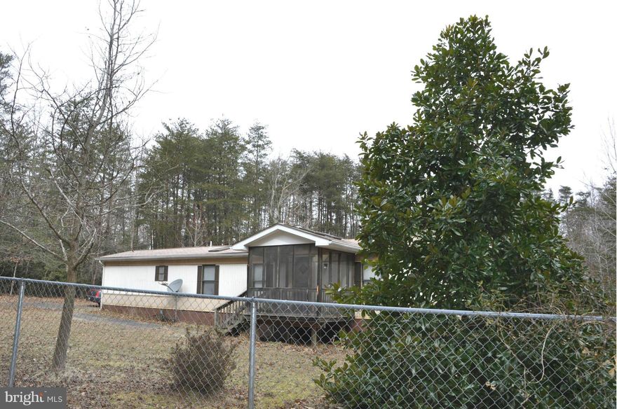 Beautiful partially fenced in property with mobile home. Land almost 2 acres. Septic and deep well. Being sold 'As-Is'. Mobile home needs repairs.  Mobile home has 2 bedrooms, 1 1/2 baths, living room, eat-in kitchen and dining room. Listing agent to provide entry into mobile home.