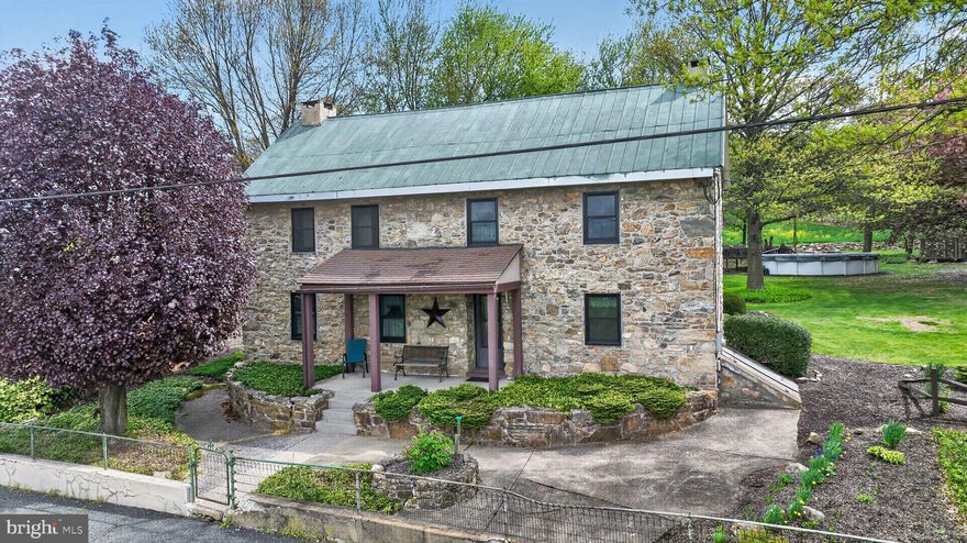 Charming Berks County stone farmhouse on 1.16 acres with lovely views. This 2-bedroom, 2-bath home has been well cared for over the past 59 years. The main level includes an eat-in kitchen, living room with wood stove, full bath, and a great room addition including a stone fireplace.
Second floor you’ll find two bedrooms and a full hall bath, plus a third-floor bonus room and attic storage.
Outside, there’s much to talk about, plenty of space to enjoy with vintage fencing, a fish pond, 25 x 20 pavilion, 28 x 27 garage/pole barn, 20 x 12 shed/workshop, and an above-ground pool. Seven new Andersen front windows were installed in 2025 for added curb appeal, and the roof was painted in 2022.
A well-maintained property with plenty of space inside and out, ready for its next chapter.
