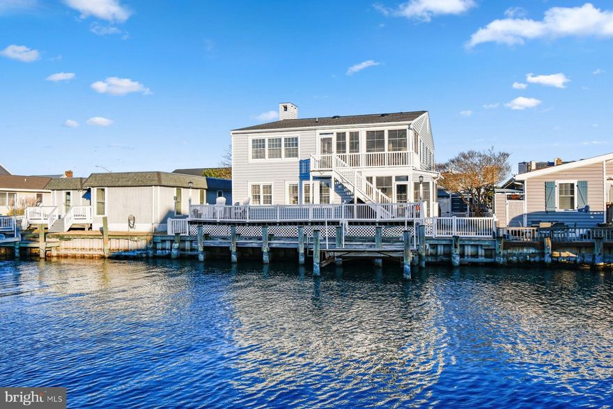 Welcome to 10615 Shifting Sands, Ocean City, MD — a spacious waterfront retreat where coastal charm meets everyday comfort (with NO HOA!). Perfectly positioned on a canal with direct access to the bay, this exceptional home offers a private dock and electric boat lift, making it ideal for boating, paddleboarding, or simply enjoying life on the water.

Featuring western exposure, the home is filled with natural light and glowing sunsets that pour in through the many windows, especially in the living room, which is beautifully lined with glass overlooking the canal. The layout is both expansive and functional, offering 5 large bedrooms and 4 full bathrooms, including a main-level bedroom that can easily serve as a home office or playroom. Two bedrooms feature en-suite bathrooms, while the primary suite stands out with a cozy fireplace, generous closet space, and inviting coastal character.

Designed for both entertaining and everyday living, the home includes an eat-in kitchen, a separate formal dining room, and an additional study with custom built-ins. Two screened-in porches/sunrooms, surrounded by windows, provide peaceful water views and the perfect spot to relax year-round.

Outdoor living truly shines here with a large waterfront deck, accessible from both the main level and top floor, offering space to gather, dine, or unwind—plus a shaded section for comfort on sunny days. After a day at the beach or on the boat, rinse off in the outdoor shower.  Updated Vinyl bulkhead, fenced in areas on both sides of the home.  Additional highlights include a one-car garage, new roof (2024), and the home being sold fully furnished for a seamless move-in experience.

Full of character, warmth, and coastal charm, this waterfront home delivers the space, setting, and lifestyle that Ocean City living is all about!