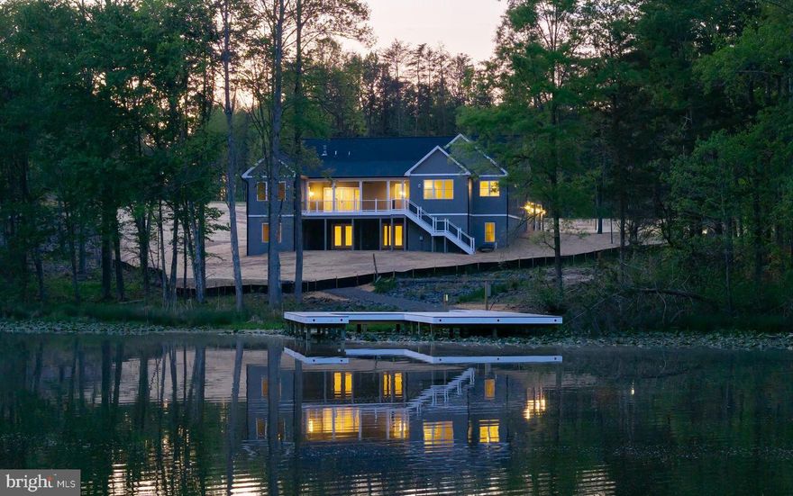 Professional photos and 3D tour coming soon! Experience elevated lake living in this brand new waterfront home on the private side of Lake Anna, Virginia, where luxury, comfort, and craftsmanship come together seamlessly. Built by award-winning Built Right Homes and nearing completion, this stunning Craftsman-style residence offers over 5,500 square feet across two beautifully designed levels. From the moment you arrive, the impressive 8-foot double front doors set the tone for what’s inside. Step into an open, light-filled floor plan featuring 9-foot ceilings, premium Mohawk LVP flooring, and a striking gas fireplace with custom built-ins. The gourmet kitchen is a true centerpiece, complete with a large island, quartz countertops, tile backsplash, stainless steel appliances, a 5-burner gas cooktop, double wall ovens, a farmhouse sink, and an oversized walk-in pantry designed for both function and style. With 6 bedrooms and 4.5 baths, there is space for everyone. The main level showcases two lakeside primary suites, each with its own private bath featuring beautifully tiled showers—one with a soaking tub—and both offering direct access to the deck overlooking the water. The main level also features two additional bedrooms that share a Jack-and-Jill bath, a convenient mudroom/laundry room and a half bath. The finished walkout basement expands your living space with a large family room, recreation area, two additional bedrooms, and a full bath. Plus, an extra 1,000 unfinished square feet offers endless possibilities—create a home theater, gym, or additional living space tailored to your needs. The exterior is just as impressive, featuring board and batten vinyl siding, 6-inch black gutters, and a partially covered back deck with a gas grill hookup—perfect for entertaining. Enjoy peaceful lake views from your level backyard, ideal for adding a pool, and take full advantage of your private dock with a sun deck already in place. Situated on a 1.5-acre lot in Compass Cove, Lake Anna’s newest subdivision, this home offers both privacy and convenience, just minutes from groceries, local dining, and Elk Creek Country Store. Whether you're cruising the lake, hosting unforgettable weekends, or maximizing income in this short-term rental friendly community, this is your chance to fully embrace the Lake Anna lifestyle—fun, relaxation, and memories all in one place.