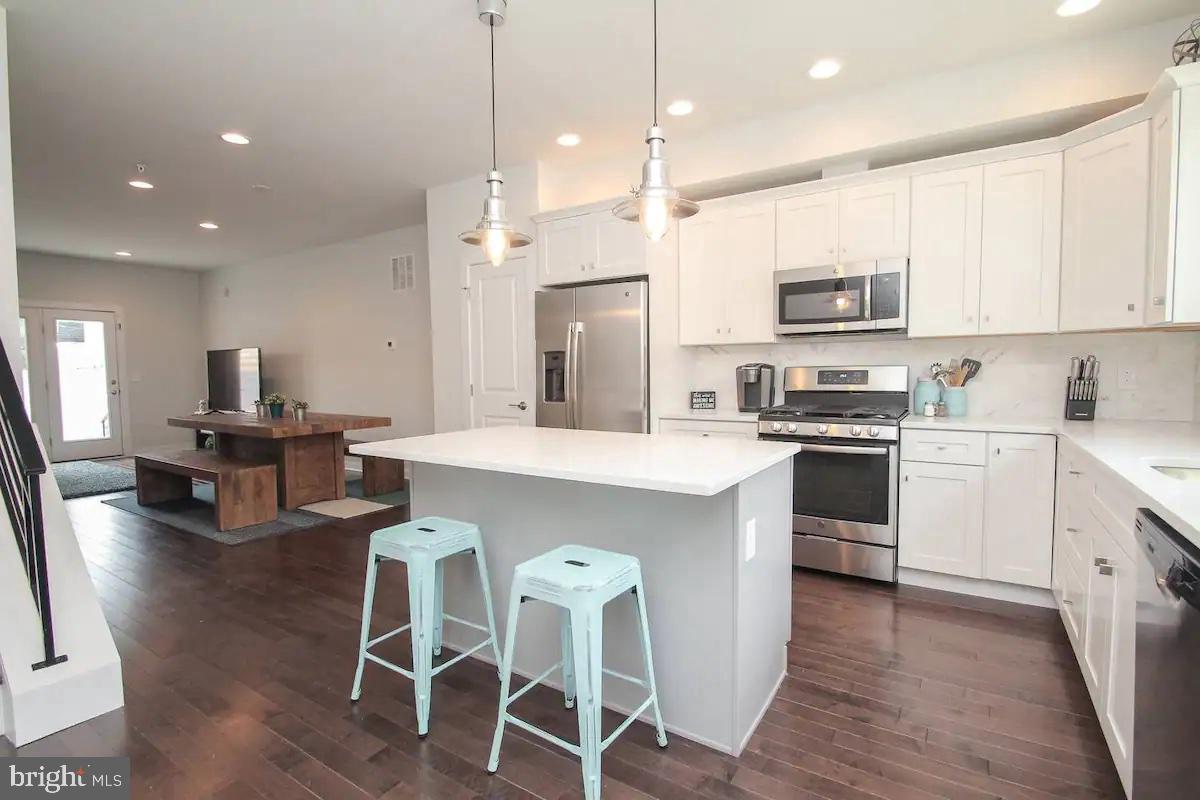 Welcome home to this gorgeous newer construction 3 story townhouse with modern and sleek finishes, recessed lighting, beautiful hardwood floors, AC, and tons of natural light throughout. Entry level has a spacious open floor plan flow, which includes a well appointed kitchen with white shaker cabinets, stainless steel appliances and quartz countetops that seamlessly flows into the living space. Off the living space there is the first of 3 private outdoor spaces, perfect for taking in the coming summer days. On the lower level there is a full bath and 2 more rooms, one of which can be used for a 4th bedroom and another room perfect for an office or entertainment space. One the 2nd floor there are two more spacious bedrooms and bathroom. Third floor has a large primary suite with a designated balcony. Continue up to the spacious roof deck with lovely views. In unit washer and dryer. Come see this beautiful townhouse which you will want to call home! Close to public transportation, shopping, grocery and many other conveniences. Available for 7.5.25 move in. Dogs under 25lbs welcome with a $500 deposit. No cats. (note: pics are of like kind unit)