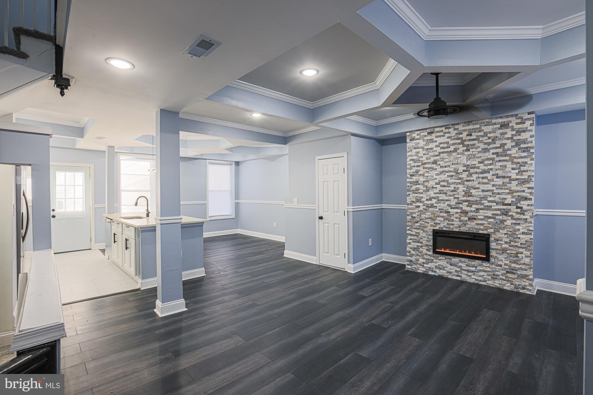 Immaculately renovated, move-in ready, 3-bedroom/3.5-bathroom townhome tucked away in northwest Baltimore. Open floor plan features tray ceilings, recessed lighting, mantled fireplace, shining LVP floors, quartz countertops, large island, breakfast bar, new cabinets, and sparkling stainless-steel appliances. Modern lighting and freshly painted gray tones perfectly accent the space. Finished lower level featuring a gorgeous full bathroom, wet bar, hidden storage, separate laundry zone w/ hook-ups, and abundant space provides the perfect living area, recreation room, entertainment space, and/or home office. Upper level boasts a large owner’s suite with a beautifully tiled full bathroom that contains a new vanity, bright lighting, and walk-in shower. Two more generously sized bedrooms, one with a HUGE walk-in closet and dressing area, and an elegantly designed additional bathroom with an adjacent linen closet complete the top floor. Exterior includes a vast covered front porch, and an immense fenced-in backyard highlighted by a new parking pad for off street parking. New electrical, plumbing, and HVAC systems provide the ultimate peace of mind. Proximity to I95, 695, 83, Towson Town Center, Hunt Valley, Foundry Row, downtown Baltimore, Sinai Hospital, Forest Park Golf Course, the Maryland Zoo, Baltimore Peninsula, CFG Bank Arena, Druid Hill Park, and so much more. Schedule a showing today!