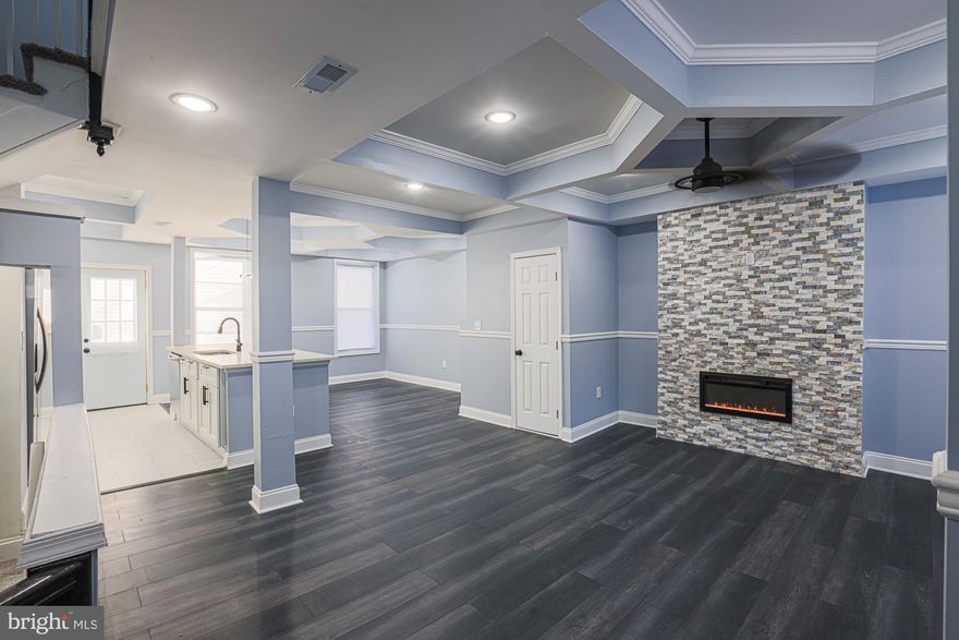 Immaculately renovated, move-in ready, 3-bedroom/3.5-bathroom townhome tucked away in northwest Baltimore. Open floor plan features tray ceilings, recessed lighting, mantled fireplace, shining LVP floors, quartz countertops, large island, breakfast bar, new cabinets, and sparkling stainless-steel appliances. Modern lighting and freshly painted gray tones perfectly accent the space. Finished lower level featuring a gorgeous full bathroom, wet bar, hidden storage, separate laundry zone w/ hook-ups, and abundant space provides the perfect living area, recreation room, entertainment space, and/or home office. Upper level boasts a large owner’s suite with a beautifully tiled full bathroom that contains a new vanity, bright lighting, and walk-in shower. Two more generously sized bedrooms, one with a HUGE walk-in closet and dressing area, and an elegantly designed additional bathroom with an adjacent linen closet complete the top floor. Exterior includes a vast covered front porch, and an immense fenced-in backyard highlighted by a new parking pad for off street parking. New electrical, plumbing, and HVAC systems provide the ultimate peace of mind. Proximity to I95, 695, 83, Towson Town Center, Hunt Valley, Foundry Row, downtown Baltimore, Sinai Hospital, Forest Park Golf Course, the Maryland Zoo, Baltimore Peninsula, CFG Bank Arena, Druid Hill Park, and so much more. Schedule a showing today!