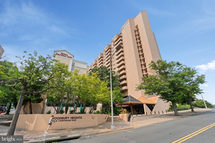 * * Absolute PRIME North Arlington Location – Assumable VA Loan at 3% - Right in the heart of Courthouse * * This light filled, move-in ready, well maintained unit features TWO generously sized split bedrooms, TWO full bathrooms, a reserved garage parking spot, in-unit washer / dryer, separate secured storage unit and all the amenities you can ask for right on the Orange and Silver Lines! As you enter #907, you’ll find the spacious living and dining areas – On one side, a breakfast bar that opens to the well-equipped Kitchen which includes Stainless Steel appliances, white cabinets and granite countertops. On the other side, the living area opens to sliding doors and an EXTRA LARGE tiled and covered private balcony - Providing a personal outdoor sanctuary and fantastic views! Perfect for entertaining! Other features include hardwood floors throughout, custom closet doors / system in primary suite with Milano glass, Hunter Douglas window treatments, custom re-claimed cherry cabinets in bathrooms with travertine and marble tile. FRESH PAINT throughout! Property conveys with a deeded parking space in the garage (#62) as well as a large, in-building secure storage unit (P3 #907). Woodbury Heights is a full-service, amenity rich, pet friendly building with a 24 hour Concierge, Fitness Center, Outdoor Pool, Sauna, Mail Package area and on-site Management. Condo fee includes water, trash and all amenities. Minutes to biking / walking paths and neighborhood parks such as Rocky Run. Surrounded by many shopping, restaurants and night life options lining Wilson and Clarendon Blvds – Enjoy close proximity to Whole Foods Market, Starbucks, Courthaus Social, Arlington Rooftop Bar & Grill, The Crossing Clarendon shopping mall and MORE! Check out the Courthouse Arlington Farmers Market on Saturdays just 1 block away! Easy commuter access to I-66, Rt 50, DC, The Pentagon, Fort Myer, Virginia Hospital Center, Amazon HQ2 and Reagan National airport with Arlington Blvd (Rt 50) just 1 block away! All this AND easy access to the Courthouse Metro stops (Orange and Silver lines) and Walk Score® of 97! WELCOME HOME!