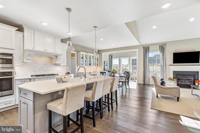 The BRYN MAWR home is designed to offer you the convenience of a first-floor living plan that suits your lifestyle. Upon your entry, the foyer opens to an elegant dining room on the left and, to the right, a guest bedroom and full bath. Just beyond, you'll find a formal study with beautiful French doors and transom.  An enormous great room makes entertaining effortless, and it's open to the gourmet kitchen so that you never miss a moment.  You'll also love the other luxury upgrades, like 5" hardwood floors and CushionClose cabinetry!  Adding the optional morning room will give you even more room to entertain or a place to enjoy your coffee or tea and your favorite book. The owner's suite is set apart, yet still convenient to the rest of the house, and features a spa-like owner's bath with soaking tub, separate shower, dual vanities and a compartmentalized water closet. Or, you can upgrade to a Roman shower to enhance the feeling of being at a private resort. Adding a luxurious look, the owner's bedroom also includes a tray ceiling.  The laundry room is conveniently located just off of the two-car garage, just a few steps from the owner's bedroom. On the second floor, there is a loft, spacious bedroom and full bath - plus, a bonus storage/office space.  In the included expansive finished basement with a fully finished bathroom, imagine your years of enjoyment as a media room, play area, home gym, and more! The Bryn Mawr offers well-appointed exterior details including Hardi Plank siding, natural stone, and bluestone walkways.  Photos are representative.