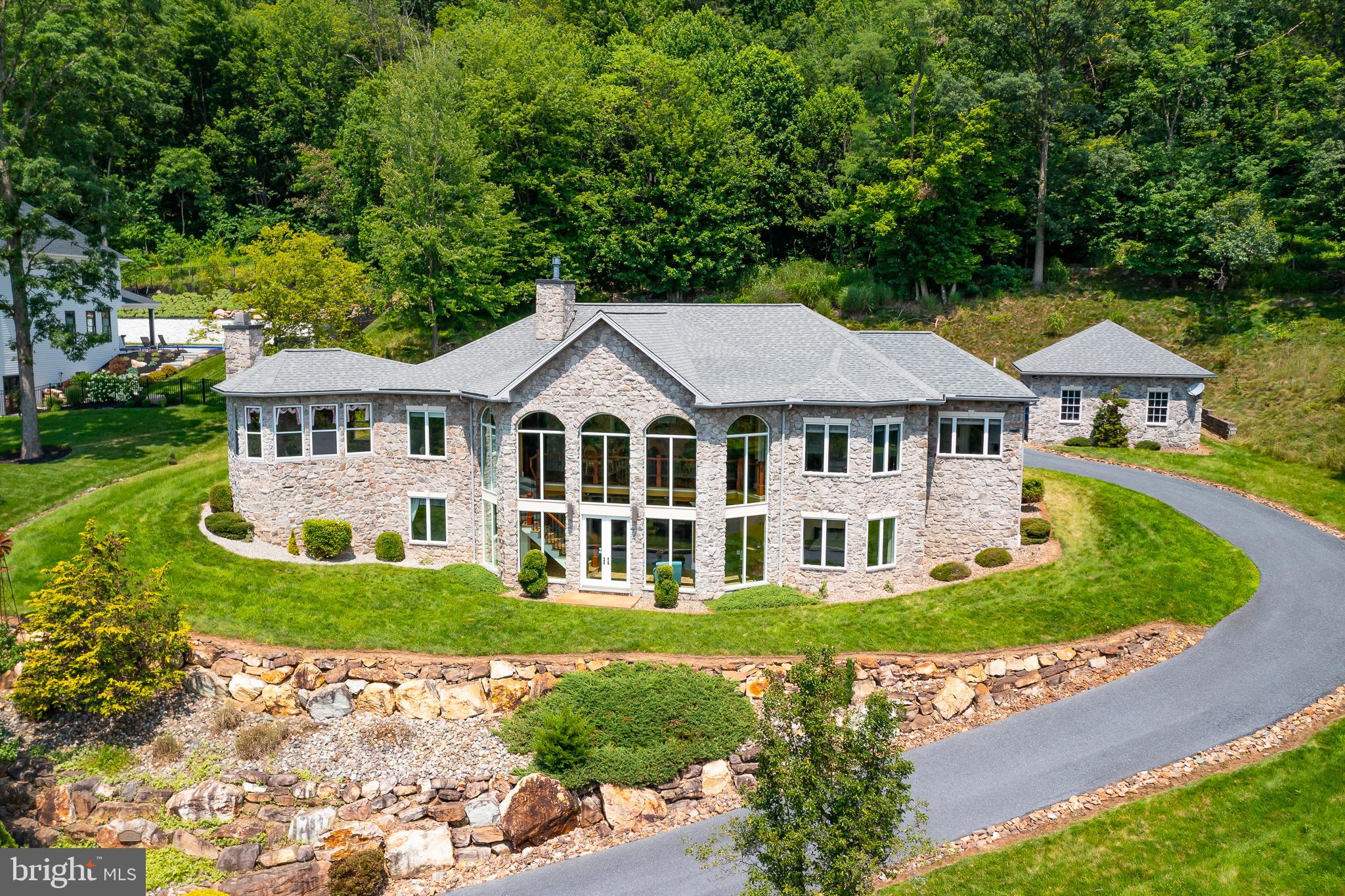 A Home That Redefines Luxury Living—With Views That Leave You Breathless
Perched above the city with commanding panoramic views of the Susquehanna river and skyline, this architectural masterpiece is a private sanctuary built for those who appreciate fine design, cutting-edge technology, and seamless indoor-outdoor living. Every inch of this custom Smart Home has been thoughtfully designed to impress—from the moment you ascend the stone-lined driveway to the tranquil courtyard anchored by a sculptural fountain. Step inside to be greeted by a soaring two-story atrium that frames the horizon like a piece of living art. By day, it floods the home with natural light and showcases nature’s grandeur; by night, with the touch of a button, it transforms into a jaw-dropping home theater—offering an immersive cinematic experience under the stars. The interior blends warmth and elegance with refined craftsmanship throughout: exotic hardwood floors, bespoke coffered, trayed, and vaulted ceilings, and rich mountain stone accents. The keeping room offers a cozy retreat, while the grand foyer leads to a luxurious primary suite complete with spa-inspired bath and private sauna—your personal wellness escape. Whether you’re entertaining guests or seeking a peaceful retreat, this home delivers an elevated lifestyle that feels both indulgent and effortless. All just minutes from the area’s top business districts, dining, and cultural amenities.