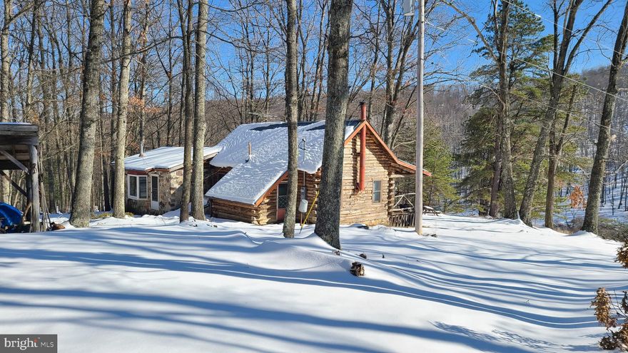 Tucked away in Hidden Valley, this cozy 2 bed, 1 bath log cabin beckons you to sit on the porch and breath in that fresh mountain air as you feel the weight of your cares wash away.   In the cooler months, the woodstove will warm you within the beautiful log interior.   The spacious kitchen/dining area will host family & friends. Plenty of room to explore, play and hunt on the 35.31 acre property.   Septic.  Cistern Water.