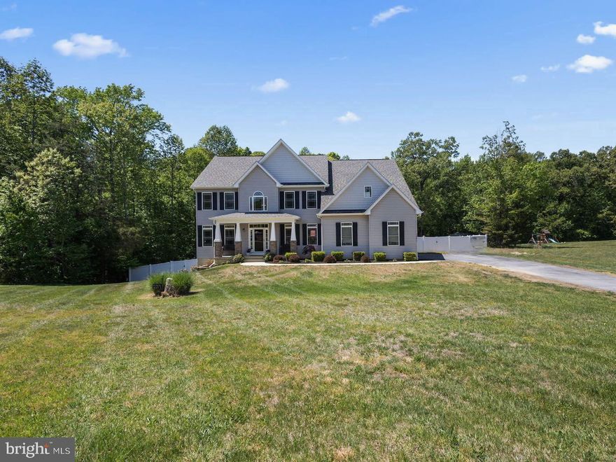 Welcome Home to Sophisticated Southern Maryland Living! This stunning residence delivers the perfect balance of refined elegance and everyday comfort — set on over an acre of private, tree-lined land with a 2-car garage and a 240V EV charger outlet already in place. From the moment you enter, the home commands attention. Rich hardwood floors anchor the main level, where a grand living room with a coffered ceiling and floor-to-ceiling stone fireplace sets the tone for memorable gatherings. The chef’s kitchen is nothing short of spectacular — featuring quartz countertops, a dramatic waterfall island, sleek cabinetry, stainless steel appliances, and designer pendant lighting that makes every meal feel like an occasion. The open, flowing layout transitions effortlessly between spaces, making this home as ideal for quiet evenings as it is for entertaining. Two flexible office/den spaces offer room to work, create, or — with the simple addition of a closet — convert into a main-level fifth bedroom. 

Upstairs, the primary suite is a true sanctuary. Expansive and serene, it features spa-inspired amenities and two walk-in closets designed for the way you actually live. The second bedroom enjoys its own private ensuite, while bedrooms three and four share a beautifully appointed Jack-and-Jill bath. With five full bathrooms spread across the home, there’s never a wait — just comfort and convenience for everyone under the roof. 

Downstairs, the partially finished lower level — freshly updated with brand-new LVP flooring — offers a versatile recreation space, a full bath, and direct backyard access. Whether you envision a home gym, media room, or guest retreat, the space delivers. Nearly 1,000 square feet of unfinished area remains, ready to be transformed to suit your vision and add immediate equity. And you’ll never run out of hot water, thanks to a tankless water heater delivering on-demand efficiency year-round.

Outside, a spacious, level yard wrapped in vinyl privacy fencing invites you to slow down and savor the seasons. A patio and pergola create the perfect setting for outdoor dining and relaxation. Young apple and cherry trees are already in the ground alongside blackberry bushes and blueberry plants — the promising beginnings of a backyard orchard that will only grow more fruitful with time. 

The location? Truly unmatched. Enjoy the peaceful rhythm of Southern Maryland living with quick access to Joint Base Andrews, Anacostia-Bolling, Dahlgren, Indian Head, I-495, and Washington, D.C. Zoned for T.C. Martin Elementary, Piccowaxen Middle, and La Plata High School — all part of Charles County Public Schools. This is more than a home — it’s the lifestyle upgrade you’ve been waiting for.