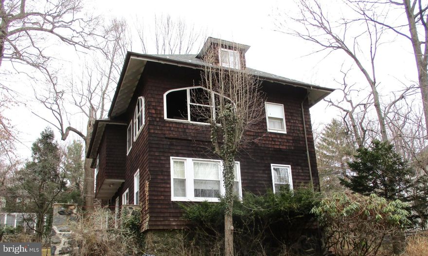 Spacious 1908 shingled style craftsman.  This home is filled with many original features.  Beautiful hardwood floors, built-in bookcases.  Spectacular wood trim throughout, wood bannisters, some replacement windows, sleeping porch, large butlers pantry with sink.  Bring your ideas, live in this while you bring it back to it's glory.  Lovely large wooded lot.  Updated 50 year architectural shingle roof.  All of this and moments from Gwynns Falls Trail.  Very active neighborhood.   Please include an "As-is" addendum.