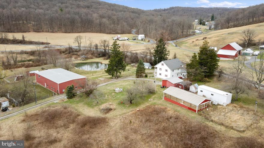 **UPDATED PRICE! MOTIVATED SELLERS!** A homesteader's dream property! Nestled on 16.19 acres, with two ponds and a creek, this home offers an escape from the ordinary and the ability to live off the land. The historic farmhouse is truly unique, with 10 bedrooms and 4 bathrooms. Great option for multigenerational living! If you're looking for charm and character, you've found it! Huge front porch and balcony, which overlooks the pond (with mountain views in the distance). Inside, the kitchen is a chef's delight, with a cooktop AND stove for a total of 10 burners! Main level in-law suite, complete with its own full bath, two bedrooms, and kitchenette. Upstairs, you'll find 7 more bedrooms and another full bath, as well as a huge storage space in the attic. The basement provides more possibilities, with a bathroom, bedroom, another kitchenette rough in, and lots of storage space. Brand new roof in 2024! The property boasts two ponds stocked with fish, a creek, a springhouse, and a greenhouse (fully equipped with water, electric, and a propane heater). Huge barn with stables, a tack room, and a hayloft, plus a fenced area ready for your animals! So many options for this home, whether you live in it yourself, AirBnB, or divide into three separate units to rent for passive income potential. Buyer to do all due diligence regarding future use. Come see it today!
