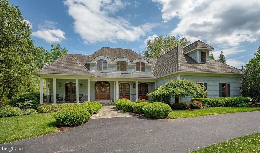 Nestled on a spectacular 1.425-acre professionally landscaped lot in the coveted Echo Valley neighborhood, 4104 Meadow Lane was custom built in 2008 and thoughtfully designed by Rene Hoffman of RA Hoffman Architects with James Hardie shingles and graceful curved windows.   This five-bedroom, four-and-a-half-bathroom home exudes timeless elegance and meticulous craftsmanship, both inside and out. 
A sweeping semi-circular driveway welcomes you, leading to a charming stone and flagstone front porch—an ideal place to relax and take in the peaceful surroundings. Inside, a gracious Foyer sets the tone with deep crown molding, 10ft high ceilings and sight-finished hardwood floors that flow through most of the home. To the right of the foyer, the formal Dining Room features a tray ceiling and two arched French doors that open to the front porch. To the left, glass-paned french doors lead to a richly appointed Home Office with a coffered ceiling, custom built-ins with a window seat and an arched French door to the covered front porch. The foyer leads to a central hall with sweeping staircase and opens to the stunning Living Room with vaulted ceiling with beams and trusses and a floor to ceiling stone fireplace flanked by arch topped French doors leading to the Sunroom with skylights, radiant heat floors and doors out to the flagstone patio and private backyard with beautiful garden beds. 
At the heart of the home is the gourmet Kitchen, a chef’s dream showcasing inset cabinetry with under cabinet lighting and an oversized island lit by stunning orb pendant lights. The appliances include a Sub-Zero wood paneled refrigerator, two Sub-Zero refrigerator drawers, 2 wood paneled Bosch dishwashers, and a suite of Thermador appliances; 5 burner hybrid induction cooktop, two wall ovens, a  built-in microwave and warming drawer. A stunning custom wood hood and elegant dark granite countertops with two undermount stainless sinks, two appliance garage cabinets and pantry cabinets complete this space. The kitchen opens to the Breakfast Room and spacious Family Room with vaulted ceiling, gas fireplace, and built-in cabinetry. 
The serene, first floor Primary Suite offers a tranquil retreat with a sitting area, two walk-in outfitted closets and the luxurious en suite Bathroom featuring radiant heat floors, soaking tub, oversized shower with bench, private water closet, and dual vanities with built-in cabinetry towers. The Laundry Room boasts cabinetry, a sink and folding counter with a window above providing natural daylight.
Upstairs, three additional Bedrooms feature charming architectural details, hardwood floors and custom outfitted closets. They are serviced by two well-appointed full bathrooms one with double sink vanity and tub shower combination and the second with both a tub and glass enclosed shower. Custom built in bookshelves in the hallway and a bonus room that provides flexibility as an office, an art studio or a guest room complete this level.
The finished Lower Level is complete with a built-in wet bar with beverage refrigerator, a gym area with wall mounted TV, and an Indoor Endless Pool. A fifth Bedroom with double closets and a full Bathroom with an oversized shower provide a comfortable space for guests. Additional highlights include a Mudroom with a family entrance and built-in lockers, a Powder Room, elevator access to the main and lower levels, and an oversized three-car Garage with custom storage by Garage Tek. The heat and air conditioning zoned per floor, whole house Generator, and on demand hot water heaters provide all the modern conveniences for today's lifestyle. 
Enjoy peaceful mornings on the front porch, cozy afternoons in the radiant-heated sunroom, or gatherings on the slate patio overlooking the professionally landscaped backyard. Positioned in a great location, this home is just minutes from Newtown Square with its many restaurants and shops.