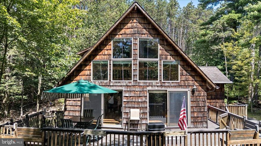 Set on 5.24 wooded acres, 670 Evergreen Rd is a private Pocono retreat blending chalet and A-frame charm with versatile spaces for year-round living, a vacation getaway, or potential investment use. The open-concept main level features vaulted wood-beamed ceilings, a dramatic wall of windows framing forest views, and a spacious living room anchored by a brick fireplace. The dining area offers direct deck access for seamless indoor-outdoor entertaining, while the kitchen provides ample counter space and natural flow. Two bedrooms, a full bath, and a cozy bar area complete the main floor. Upstairs, a lofted landing leads to two additional loft rooms, a second full bath, and a private loft-style bedroom—perfect for guest quarters, offices, or creative spaces. The 36’x26’ walk-out basement offers abundant storage or the option to finish for added living space. Outdoors, enjoy an expansive wraparound deck, built-in garage, and a peaceful wooded setting. Located minutes from the PA Turnpike, Beltzville Lake, and top Pocono attractions, this property offers the perfect blend of rustic character and modern convenience. With nearby hiking, boating, skiing, and dining, it’s an ideal escape or investment in the heart of the Poconos. Schedule your showing today.