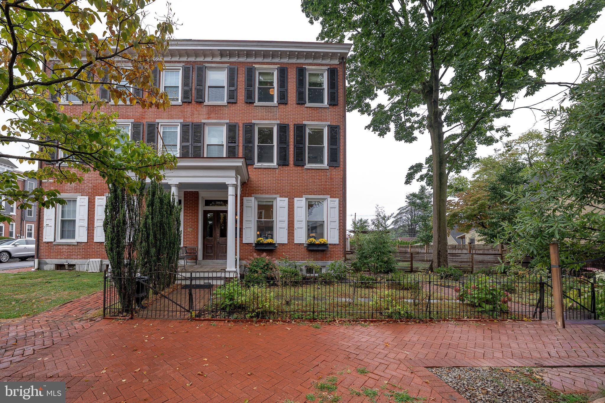 We invite you to walk back in time where elegance meet style to create this amazing three-story 3,366 sq ft home! 303 South Church Street is an historic home with fully renovated interior. Taken down to the studs in 2017 and fully renovated by Pine Street Carpenters. It is a classic Federal Style brick twin home, situated on a double fenced lot complete with multi-car parking and a garage off the alley all located within walking distance to everything that West Chester offers. Enter an elegant double entryway into the first floor with tall ceilings and lovely old world glass doors, windows and transoms. Breathe in the stories and history as you enter the living room with tall windows, wide plank white oak flooring (all from one tree!) and beautiful millwork. Transition into a large family room with a fireplace and a second recreation room with built-in book shelves. As you move to the heart of the home, there is a huge kitchen with soapstone counters, huge island with seating for five, Blue Star six-burner gas stove, two ovens, tile backsplash, deep porcelain sink, Blue Star refrigerator and fireplace. Each room is light and spacious with wonderful views of the large covered porch and gardens. The gardens were also fully renovated by Green Roots including drainage, irrigation, planting and lighting. Completing the first floor are: mud room, laundry room and powder room with tile flooring an an exit for a short walk to the garage and alley parking. The second floor hosts the primary bedroom with a beamed vaulted ceiling, huge organized walk-in closet, wonderful light and carpeted flooring. The en-suite bath has a double vanity, soapstone counters, tile flooring, large walk-in glass tile shower and cathedral ceiling. There are two additional large bedrooms with pine flooring, ceiling fans and ample closets and a hall bath with a trough sink for two, glass shower door and radiant heat tile flooring. The lovely architectural details, high ceilings, hardwood flooring and beautiful large windows extend throughout the second floor. The third floor has two additional rooms as well as attic space with ample storage. New electric, new plumbing, new HVAC (two zones, new ductwork throughout) and all new windows. This home has been lovingly updated and cared for and will be an exceptional place to call home!