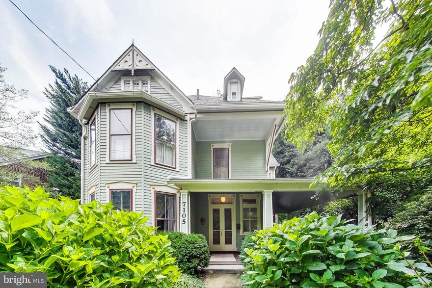 A rare Victorian treasure nestled in Takoma Park’s Historic District and central village location near Red Line Metro station, city hall and community center, public schools, town library, farmers market, shops, and restaurants; built in 1886 and featuring authentic architectural details: soaring ceilings; recessed wood, raised, paneled, pocket, and etched glass doors; burnished wood floors; a variety of oval, skylit, leaded, and transom windows; bullseye moldings, medallions, and chair rails; wraparound porches and balconies; all carefully preserved and updated by long-time owners. Four finished levels consist of seven (7) bedrooms, four-and-one-half (4.5) bathrooms, which includes a 2-bedroom IN-LAW SUITE. Here is a genuine collector’s item whose lush perennial gardens and sweeping wooded lot instill a sense of calm and respite. A National Register of Historic Places Nomination states "...7105 Holly Avenue is a late vernacular treatment of the cottage style of the mid-19th century. The many gabled elevations and the carpenter's Gothic verge boards attest to this fact...". Today's amenities and features include central air conditioning; built-ins galore; ample storage; a chef's kitchen loaded with cabinetry and stainless appliances; main-level mudroom and laundry; a two-bedroom IN-LAW SUITE; and lush perennial gardens.  Three levels of this home have generated  as much as $775 per day in short-term rental income. Appraisal figures for finished square footage above and below grade:  4,127; unfinished below grade:  370. You’ll love living in this historic gem.