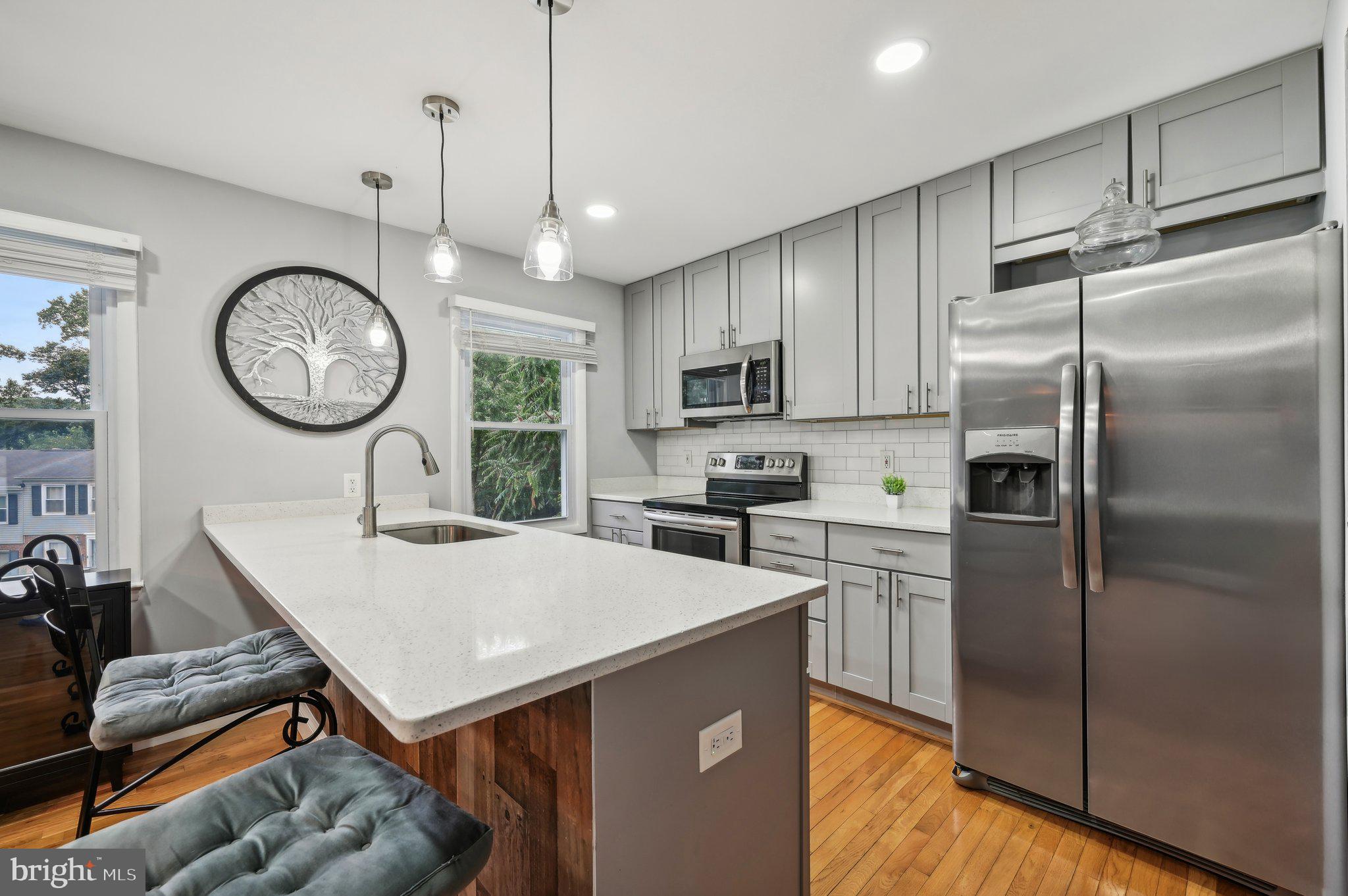 Incredible opportunity to own an amazing 2021 renovation! The main level's open floor plan is welcoming with a spacious living room and dining area open to the kitchen which features stainless steel appliances, quartz countertops and a large island. There's also a convenient half bath on the main level. Upstairs you'll find three bedrooms and a tastefully renovated full bath. The fully finished walkout basement is perfect for movie night and entertaining. Another beautifully renovated full bath and laundry complete the lower level. There are gleaming hardwood floors on the main and upper levels with vinyl plank floors in the basement. The rear yard is completely fenced and accessible from the walk out basement. New basement floors and washing machine were installed in 2024. This home is close to shops, restaurants and major commuter routes. Have your agent schedule a tour online via the MLS or contact the listing agent!