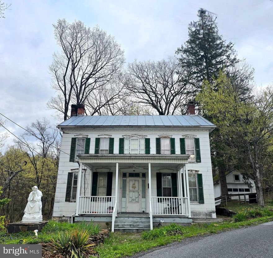 HISTORIC COLONIAL SITUATED ON .51 ACRES JUST OUTSIDE DOWNTOWN BERKELEY SPRINGS, WV (TOWN OF BATH)!  This 1877 home features a kitchen with an electric range, a dining room with a pellet stove, a living room with an electric fireplace, and a half bath, all on the main level with wood flooring and vinyl throughout.  Upstairs, you will find the primary bedroom with a walk-in closet, as well as two additional bedrooms, one of which could serve as a sitting room.  There is also a full bath on the upper level with a claw-foot tub/shower. The property includes public water and sewer, as well as Xfinity/Comcast internet for high-speed web browsing.  With such close proximity to downtown Berkeley Springs, this property has immense potential – make it your primary residence or utilize it as an additional source of income through rental or Airbnb.