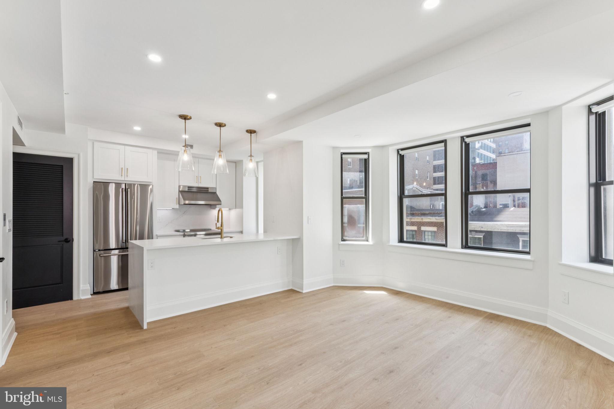 Brand new two bedroom, two bathroom with sunset city views and modern finishes at The Wellington on Rittenhouse Square! This new construction home features an open great room with two walls of oversized windows showcasing beautiful sunset views and ample space for living, dining, and entertaining; a sleek modern kitchen with white shaker cabinetry, quartz countertops and backsplash, GE stainless steel appliances, and a breakfast bar; a spacious primary suite with floor-to-ceiling windows, two wall closets, and an ensuite bathroom with a contemporary double vanity, glass-enclosed shower, and calacatta tilework; a generously sized second bedroom with oversized windows and excellent closet space; full hall bathroom appointed in calacatta tilework with modern vanity and glass-enclosed shower; stacked LG washer/dryer; and recessed lighting, excellent closet space, and vinyl floors throughout. This home also enjoys individual heat & air conditioning controls. The Wellington is a pre-war apartment building located on Rittenhouse Square offering a 24 hour doorman, on-site management, and access to a nearby fitness center at 1845 Walnut. Tenants are responsible for paying all utilities.