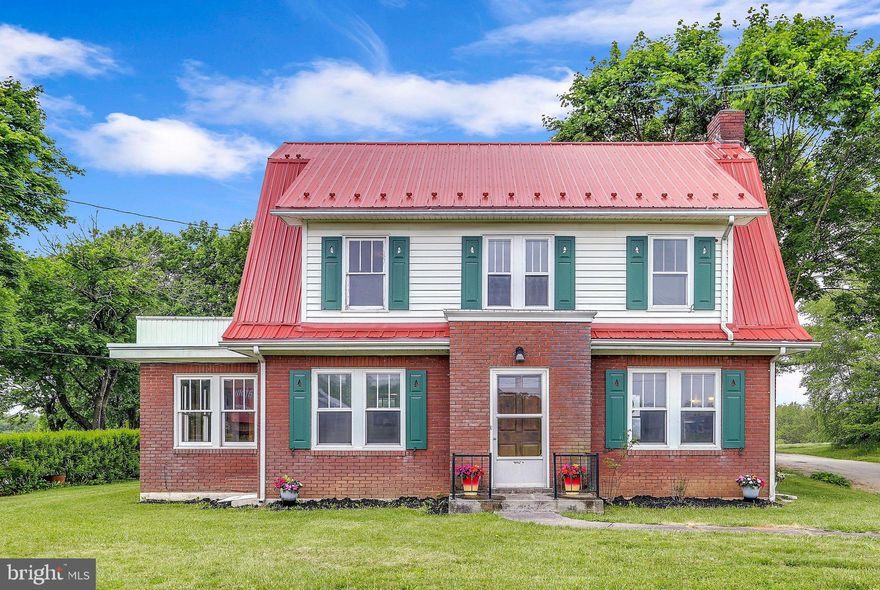 Farmhouse style - everyone tries to recreate it, but few are fortunate enough to call one of these iconic American properties home.  Built in the 1950's, this classic 3 bedroom, 1.5 bath farmhouse has all the original hallmarks of style, plus the convenience of a modern, newly updated kitchen with quartz countertops, Shaker-style cabinets and  stainless steel appliances.  With original oak woodwork throughout including a beautiful staircase with built-ins on the landing, and wood-burning stone fireplace in the living room, you will be enchanted by its charm.  All three bedrooms have gorgeous hardwood flooring, and the master has its own terrace where you can enjoy your morning coffee.  Both the full bath and half bath are newly renovated, and the main level flooring is brand new as well.  The spacious main level boasts the new kitchen, beautiful dining room and living room, plus a sun room, mud room just off the kitchen, and front entrance foyer.  With the new, upgraded metal roof, water softener and whole house filter, this home offers both substance and style. And you'll love the detached garage with workshop, all on just under 1 acre surrounded by farmland.