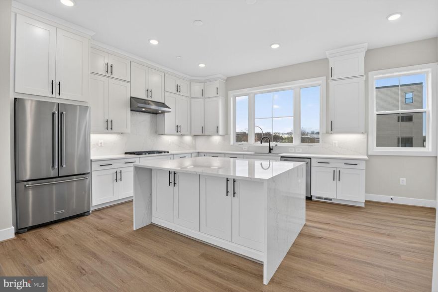 This stunning end-unit home features a bright and open main living level with a spacious great room, a sunlit dining area, and a rear kitchen with a waterfall island. The Chef’s dream kitchen is complete with Artisan Brightest White stacked cabinets, Ethereal Haze quartz countertops, KitchenAid stainless steel appliances, and matte black hardware. Upstairs boasts a luxe primary suite with two walk-in closets and upgraded primary bath. Two additional bedrooms and a full bath complete the bedroom level. The upper level features a large loft that opens to a rooftop terrace and extended covered outdoor living area. An additional bedroom and full bathroom complete the lower level.