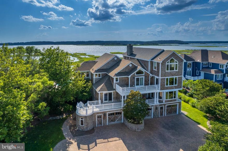 Masterfully built 1 Maisons Sur-Mer House boasts magnificent appointments and mesmerizing water views! This custom, unparalleled 7BRs/6 full baths/4-car garage/4PR estate reigns over prime and private enclave tucked between rippling water of Little Assawoman Bay and rhythmic waves of Atlantic Ocean. Deemed as treasured family compound, grand curved walls grant entrance up winding paver driveway to breathtaking 8,308 sq. ft. and 13,616 sq. ft. (estimated total) home of multiple pitched rooflines (new roof 2020), stone turrets, imposing front and 3-levels of luxurious living in coastal town of Fenwick. Nestled on over 2 acres, this estate-like home offers resort-style getaway of highest standards and is enveloped in an aura of tranquility and serenity. Original home was built in 1998 and in 2003 large 5,000 sq. ft. addition and renovation was completed to culminate in a work of art. Own it and enjoy it. Rent it and reap the rewards. Although home has never been rented, rental potential is 10K per week! Appreciate generous usage of pristine glass sliding doors, apex-style windows, bay windows and elegant French doors that offer uninterrupted, flawless views to both ocean and bay from countless vantage points of home and blend with vaulted and trey ceilings, detailed wainscoting, statuesque columns, rich built-ins and decadent crown molding to create a true architectural masterpiece like none other! Welcome the open concept great room with FP, state-of-the-art gourmet kitchen with SS appliances, tile backsplash and gorgeous cream cabinetry including unique and spectacular center island, and lovely dining room that exudes pure elegance and calls for instant enjoyment. These rooms are seamless to each other, while multiple glass sliders line back wall and cast natural sunlight onto this fabulous trio of rooms. Curl up with good book and bask in glorious natural light and resplendent views in tile-floored, windowed walls, sun-infused Florida room. Unwind in expansive FR with trey ceiling, and 2 bump-out areas, 1 is home to dining nook, while other features series of windows and affords bay views. Gather friends and families to play a game of billiards or rousing round of cards in something-for-everyone game room. Let children enjoy sprawling, ground-level playroom. Invite guests for weekend-to-week-long stays with sumptuous guest suites, and delight in soundless elevator that can whisk all effortlessly to all levels of home! Observe wide plank English Oak floors, multiple fireplaces, custom bathroom vanities and high-tech audio and surround sound. Indulge in 39 x 19 opulent primary suite positioned on top floor by itself wrapped in seclusion. Be amazed at striking hardwood floors, sweeping walk-in closets, splendid gas FP, and windowed retreat area, all overlooking Little Assawoman Bay. Primary bath features apex window, wide-planked vaulted ceiling, walk-in tiled shower and soaking tub with views of Atlantic Ocean. It is luxury at an unmatched level! Step outside onto one of numerous decks and take in stunning natural setting, value extensive hardscaping and exterior lighting bordering home, swim in bayfront pool while relishing seemingly boundless views of water, lounge and sun on 57 x 37 surrounding deck, revel in tiled floor family room with wet bar just off pool deck and wind down in whimsical outdoor shower. Home is designed to embrace and entertain! From winter dinner parties to summer BBQs, it is perfect home for year around soirees. Best of all, when desired, relax and appreciate harmony and symmetry of the deep pink, hues of coral, brilliant orange and streaks of red as they paint the sky for endless sunrises and sunsets you will savor. Home is merely minutes from charming beach town of Bethany, chock full of boutiques, fine dining, enchanting boardwalk and more! This waterfront coastal beauty is extraordinary, exceptional and everlasting. It is everything you could want in beach living and more!