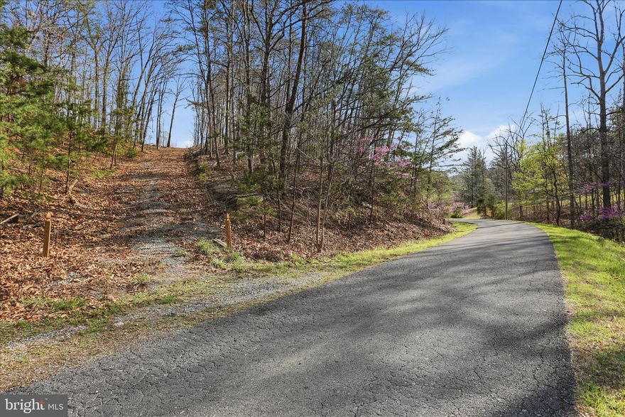 Discover the perfect blend of privacy and natural beauty with this 5.49-acre parcel on Whispering Knolls Dr in Winchester, VA. Nestled among scenic country roads, this property offers a peaceful setting to build your dream home. Located approximately 6 miles from I-81, it provides a manageable commute while still offering the charm of rural living. Winchester Medical Center is less than 10 miles away, with farmers markets, dining, and shopping also within easy reach. Situated off a paved road, the property features an established driveway (in need of improvement), along with a completed survey and soil study—saving you time as you plan your build. Whether you're ready to build now or simply looking for a serene piece of land to call your own, this property captures the beauty and simplicity of country living.