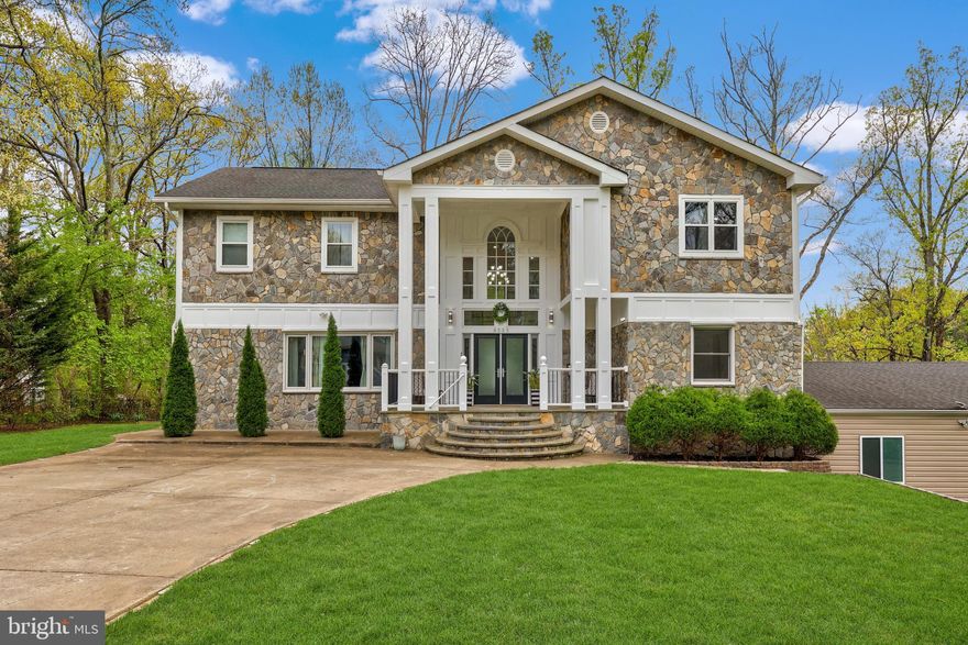 Welcome to this beautifully updated colonial offering over 5,000 square feet of living space in the highly sought-after Wakefield Forest neighborhood and the Wakefield Forest Elementary, Frost Middle, and Woodson High School pyramid. Situated on a spacious half-acre corner lot, this impressive home features two driveways and a three-car garage, providing both convenience and exceptional curb appeal.

Completely reimagined from top to bottom in 2015, this expansive home features a full upper-level addition and a stunning exterior transformation, offering the perfect blend of scale and thoughtful design. Major systems—including plumbing, HVAC, electrical, full home recessed lighting, and roof—were all updated as part of the renovation, providing both modern comfort and peace of mind. From the moment you step inside, you’re greeted by a dramatic two-story foyer, where a grand double staircase creates a striking and unforgettable.

The main level showcases beautiful Brazilian cherry hardwood flooring throughout and an abundance of natural light. Designed with both everyday living and entertaining in mind, the open floor plan flows effortlessly between the living spaces. The spacious dining room sits adjacent to the gourmet kitchen, which features a large island, stainless steel appliances, granite countertops with matching backsplash, and warm wood cabinetry. Architectural details such as crown molding, arched columns, and recessed lighting add character and elegance throughout the main level.

Just off the main living area, double french doors lead to an oversized Trex deck overlooking peaceful greenery—an ideal setting for relaxing evenings or hosting gatherings with family and friends. This level also includes a powder room and a main-level bedroom that offers flexibility as a guest room or private home office.

Upstairs, the Brazilian cherry hardwood flooring continues throughout the upper level. The spacious primary suite serves as a true retreat, featuring two walk-in closets and a spa-like en-suite bathroom with a double vanity topped with quartz countertops, a jetted soaking tub, and a separate standing shower. Three additional bedrooms complete the upper level, including one with its own en-suite bathroom and two that share a well-appointed hall bathroom.

The walk-out lower level provides even more living space with a large recreation room perfect for a game room, media room, or additional entertaining space. A separate room off the garage offers an excellent opportunity for a home gym, while the lower level also includes a full bathroom, a bonus room, and a den that can be reimagined to suit your needs, whether as a larger laundry room, additional living space, or hobby area.

Conveniently located just off Little River Turnpike, this home offers easy access to I-495 and is only minutes from Old Town Fairfax, Pickett Shopping Center, Fair City Mall, INOVA Fairfax Hospital, Mosaic District, and Tysons Corner. With its expansive living space, prime location, and highly desirable school pyramid, this home presents an exceptional opportunity.