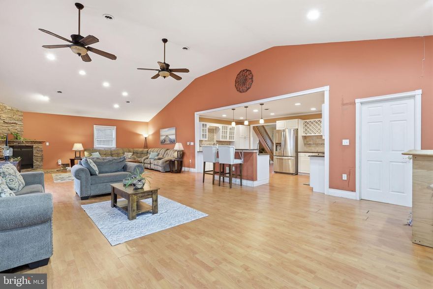 Expanded, remodeled, and absolutely stunning Cape Cod in the highly desirable Highland Park neighborhood of Levittown within the sought-after Neshaminy School District, located directly across from Carl Sandburg Middle School. This beautifully maintained 3-bedroom, 2-bath home offers over 2,200 square feet of upgraded living space featuring a gourmet kitchen with granite countertops, tumbled marble backsplash, vegetable prep sink, stainless steel Kenmore appliances including a double oven and built-in convection microwave, wine rack, and spacious eat-in island. The kitchen opens to a dramatic great room with soaring cathedral ceilings, floor-to-ceiling stone fireplace, custom bar with Beer Meister system, ceiling fans, and abundant recessed lighting. A sun-filled formal dining room with chair rail detailing adds elegance, while the first-floor primary suite offers a walk-in closet and remodeled expanded bath. The main level also includes a large mudroom with garage access and laundry. Upstairs you’ll find two generously sized bedrooms and a remodeled full bath. The fenced backyard is perfect for entertaining with a stamped concrete patio and fire pit area. Additional features include central air, attached garage, and public utilities. Conveniently located near major highways, shopping, dining, and parks, this home combines comfort, community, and convenience — don’t miss the opportunity to make it yours.