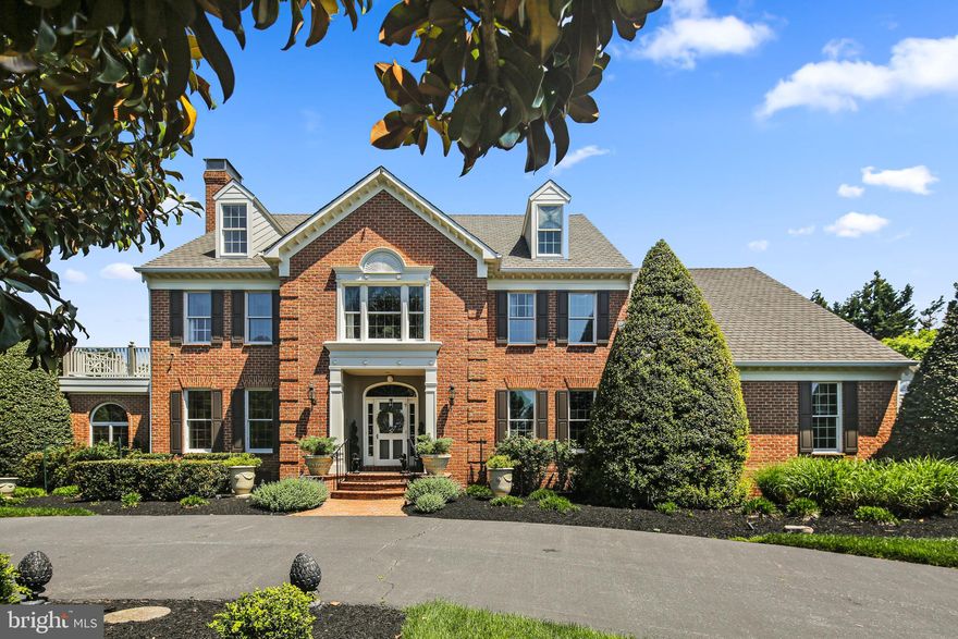 Step into the timeless elegance of this custom Williamsburg colonial, where grandeur meets gracious living. A sweeping circular driveway welcomes your guests to the majestic foyer, setting the stage for the opulence that awaits within. Entertaining is effortless in the expansive formal rooms of the home. The magnificent living room, adorned with an attached conservatory bathed in natural light, shares a double-sided fireplace, creating an atmosphere of sophistication and warmth. Adjacent, are stately dining room and family room with another fireplace, offering intimate settings for gatherings and relaxation. The heart of the home lies in the bright white kitchen, where counter space abounds and culinary creativity flourishes. A sprawling walk-in pantry with prep sink and a butler’s pantry cater to every hosting need, while a convenient wine bar, complete with its own dishwasher and sink, seamlessly connects the dining room and kitchen. For those who work from home, the office provides a serene backdrop overlooking the lush backyard. Dual 2-car garages, accessible from both the rear entranceway and an enclosed breezeway, ensure ample parking and storage space. Ascending the grand circular staircase or the back staircase from the kitchen, the second floor unveils a private oasis in the form of the owners’ suite. Complete with an attached sitting room opening to an outdoor balcony, dual walk-in closets, and a remodeled spa-like bath, relaxation is paramount. An additional bedroom with balcony access and private bath, along with two more bedrooms, a bathroom, cedar closet, and large laundry room, round out the floor. Discover ultimate flexibility with a full in-law/nanny/guest suite, boasting a living room, full kitchen, two bedrooms, and a bath, accessible via a discreet hall door. Below, a finished lower level beckons with a second family room, expansive game room, and wet bar, offering endless entertainment possibilities. Abundant storage ensures functionality and organization throughout. Attention to design and detail is evident at every turn, with extensive moldings and decorator touches transforming this residence into a true showplace. State-of-the-art mechanicals, including a propane-driven whole house generator, guarantee peace of mind even in the face of power outages. Step outside and be transported to an idyllic English countryside on the sprawling 4.13 acre lot. Beautifully landscaped formal gardens, shaded by majestic trees, invite leisurely strolls and alfresco dining, while secluded patios offer moments of tranquility and privacy amidst nature’s embrace.