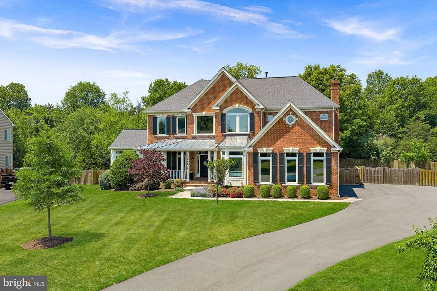 Set on a private, wooded homesite in the heart of Ashburn, this exceptional cul-de-sac residence offers a rare blend of seclusion, sophistication, and fully integrated smart living. Tucked away yet minutes from everyday conveniences, the property delivers a lifestyle that feels worlds apart—where privacy, innovation, and comfort exist in perfect balance.

Almost completely reimagined in 2020 with a no-expense-spared approach, the home has been transformed into a truly connected smart residence. Nearly every light, system, and function—from climate and security to whole-home audio—is app-controlled and seamlessly integrated. Thoughtful infrastructure upgrades including a whole-house surge protector, leak detection with automatic water shutoff, and high-efficiency systems (roof, HVAC, and dual Navien tankless water heaters all updated in 2020) provide peace of mind alongside luxury. Sonos speakers in every room, custom built-ins, flat wall vents, and Pella windows with between-the-glass blinds reinforce the level of detail carried throughout.

The interior balances modern design with warm, highly functional living. The kitchen is a true showpiece, outfitted with a full suite of designer appliances including a Big Chill industrial refrigerator, 48” gas range, Miele built-in coffee system, steam oven, and more—blending performance with statement design. Supporting spaces like the butler’s pantry elevate everyday living with a full refrigerator/freezer set, ice maker, pull-out storage, and hidden outlets. The dining space is equally impressive, with custom cabinetry, color-changing LED shelving, and a dual-temperature wine fridge.

The primary suite offers a true retreat experience, complete with a retractable ceiling-mounted TV, custom-designed closet with island and rotating storage, and even an LG steam closet for garment care. The spa-inspired bath features a dual steam shower, heated floors, heated towel rack, cast iron soaking tub, and smart mirror cabinetry—creating a space designed for both relaxation and performance. (And yes—there’s a hidden feature you’ll want to see in person.)

The fully finished lower level continues the home’s elevated design, featuring coffered ceilings, a sound-insulated brick feature wall, and a modern open staircase with sleek railings. This level offers exceptional flexibility for entertaining, recreation, or extended living, with a dedicated gym space (that can easily convert to a fifth bedroom), a full bath, and multiple areas for gathering or relaxation.

Outdoor living rivals that of a private resort. A renovated pool with sun shelf, a separate hot tub, expansive decking, and multiple entertaining zones are complemented by a fully equipped outdoor kitchen with grill, griddle, smoker, and refrigeration. The StruXure motorized louvered roof system—on both the main deck and private office deck—automatically responds to weather, with integrated lighting, screens, heaters, and fans creating year-round usability. Landscape lighting, uplighting, irrigation, permanent Jellyfish lighting, and whole-property Sonos audio complete the experience, all set against a mature tree-lined backdrop for exceptional privacy.

Additional highlights include an oversized garage with dual EV chargers, epoxy flooring, built-in cabinetry, and boot heaters; extensive storage solutions including fully-enclosed  under-deck storage; and countless thoughtful upgrades designed for both convenience and longevity . Many furnishings were custom-made or purchased for this home & may convey.

This is more than a home—it’s a thoughtfully engineered lifestyle. With advanced technology, exceptional craftsmanship, and indoor-outdoor living executed at the highest level, this is a truly rare offering for those who expect both beauty and performance from where they live. Home provides easy access to Ashburn Metro Station, Dulles Airport, Loudoun County Parkway, Route 28 and Dulles Greenway and Toll Road,
